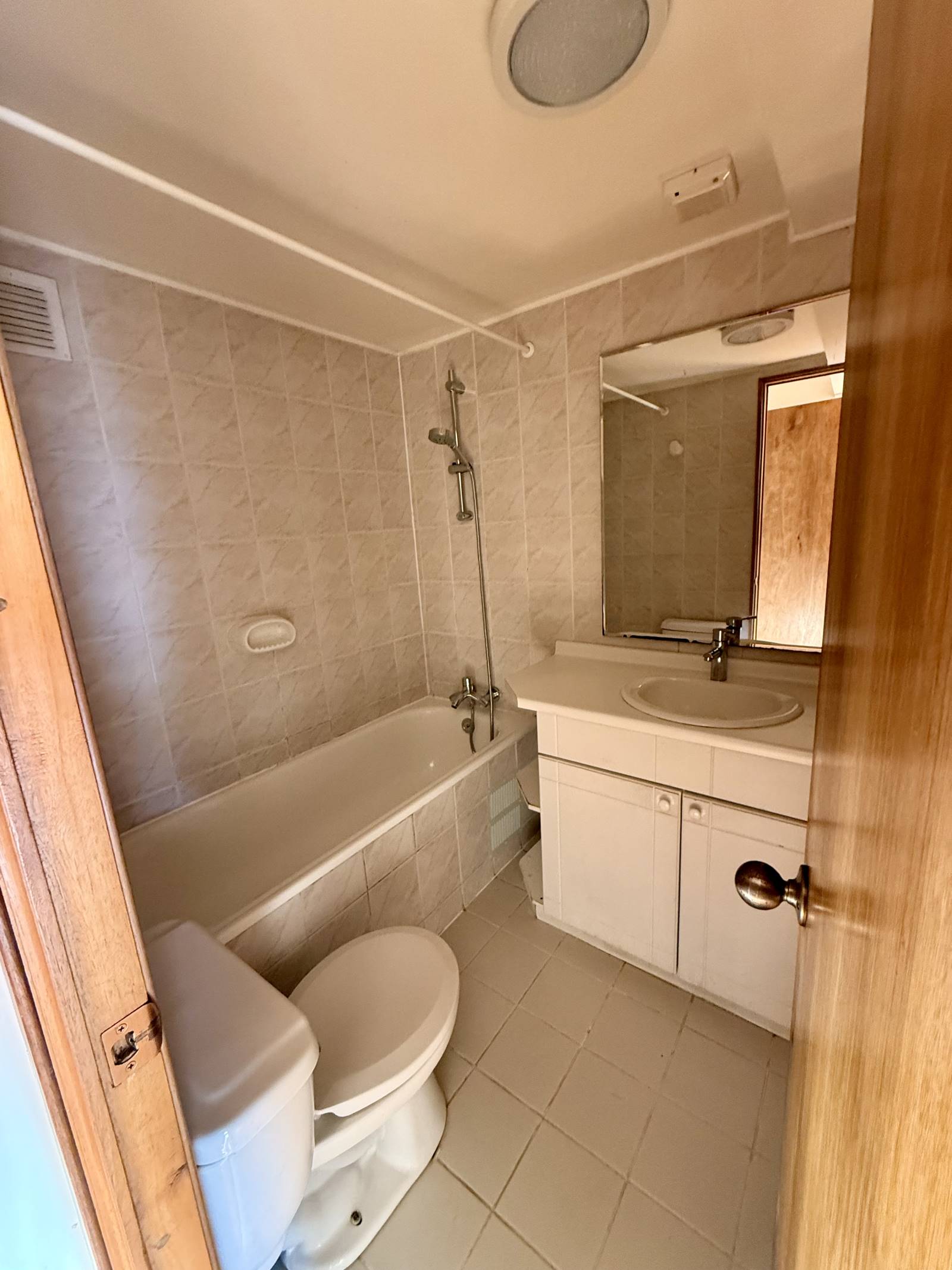 Baño con tina completa, inodoro y mueble lavamanos