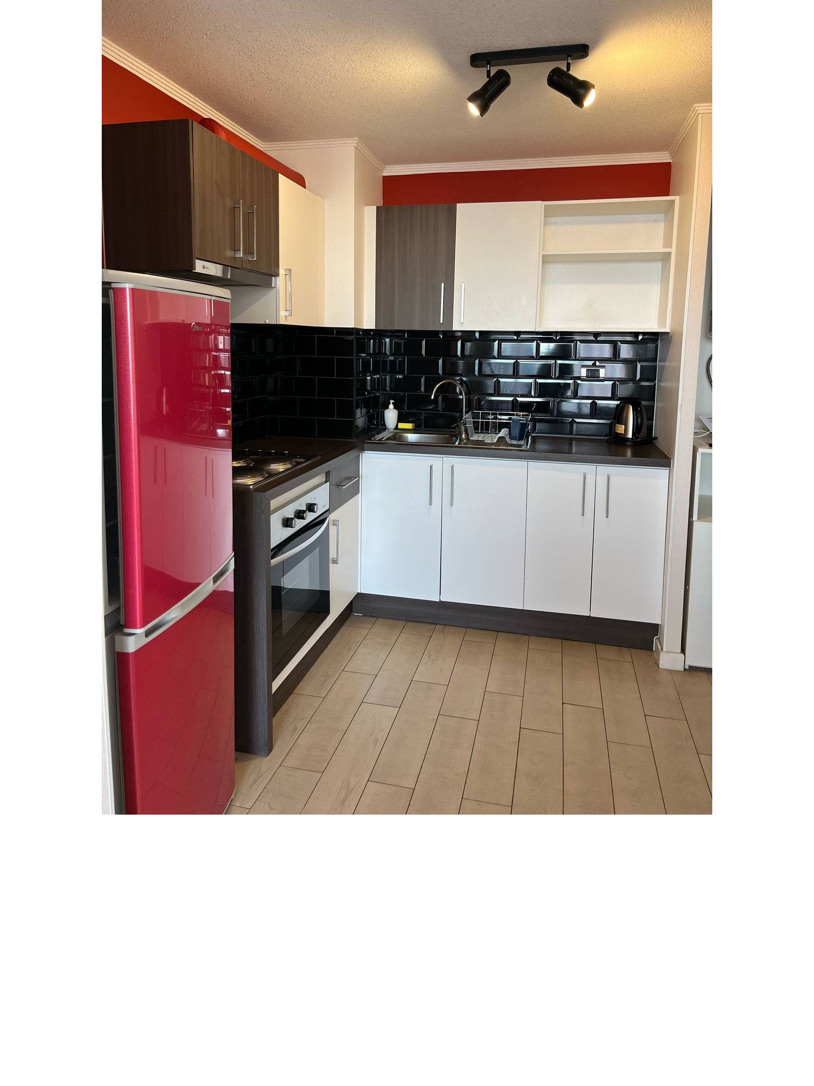 Cocina equipada con encimera, horno y muebles empotrados