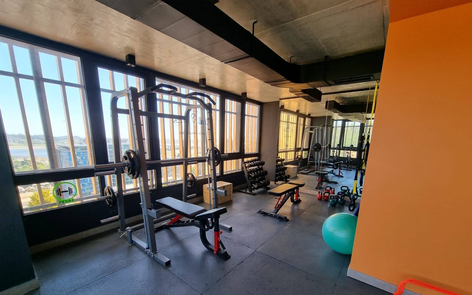 Gimnasio equipado con máquinas y pesas del edificio
