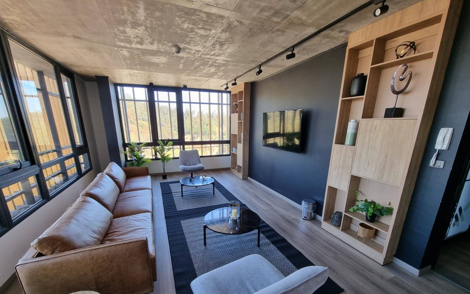 Sala lounge comunitaria con sillones y televisión