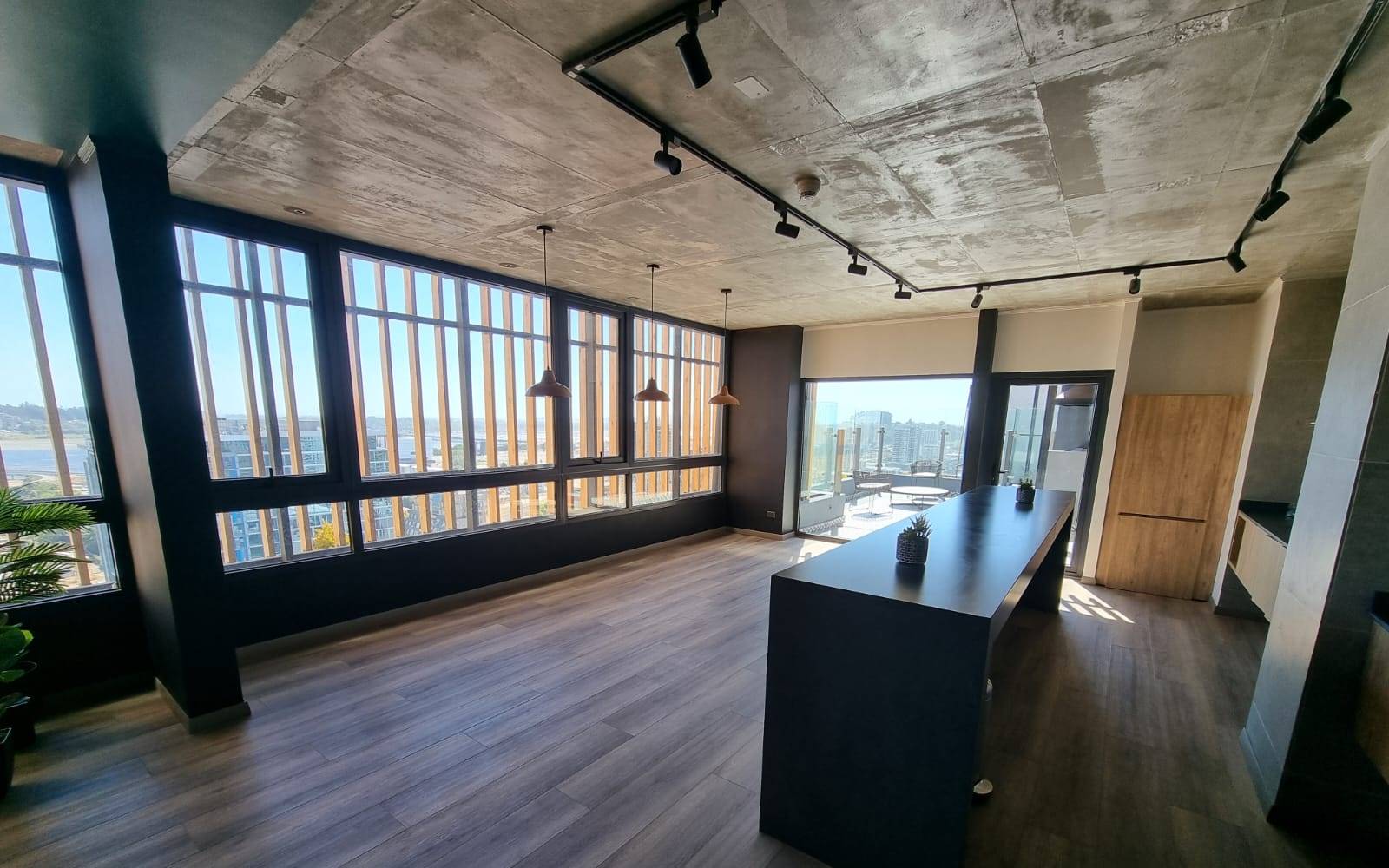Salón gourmet espacioso con gran isla y ventanales