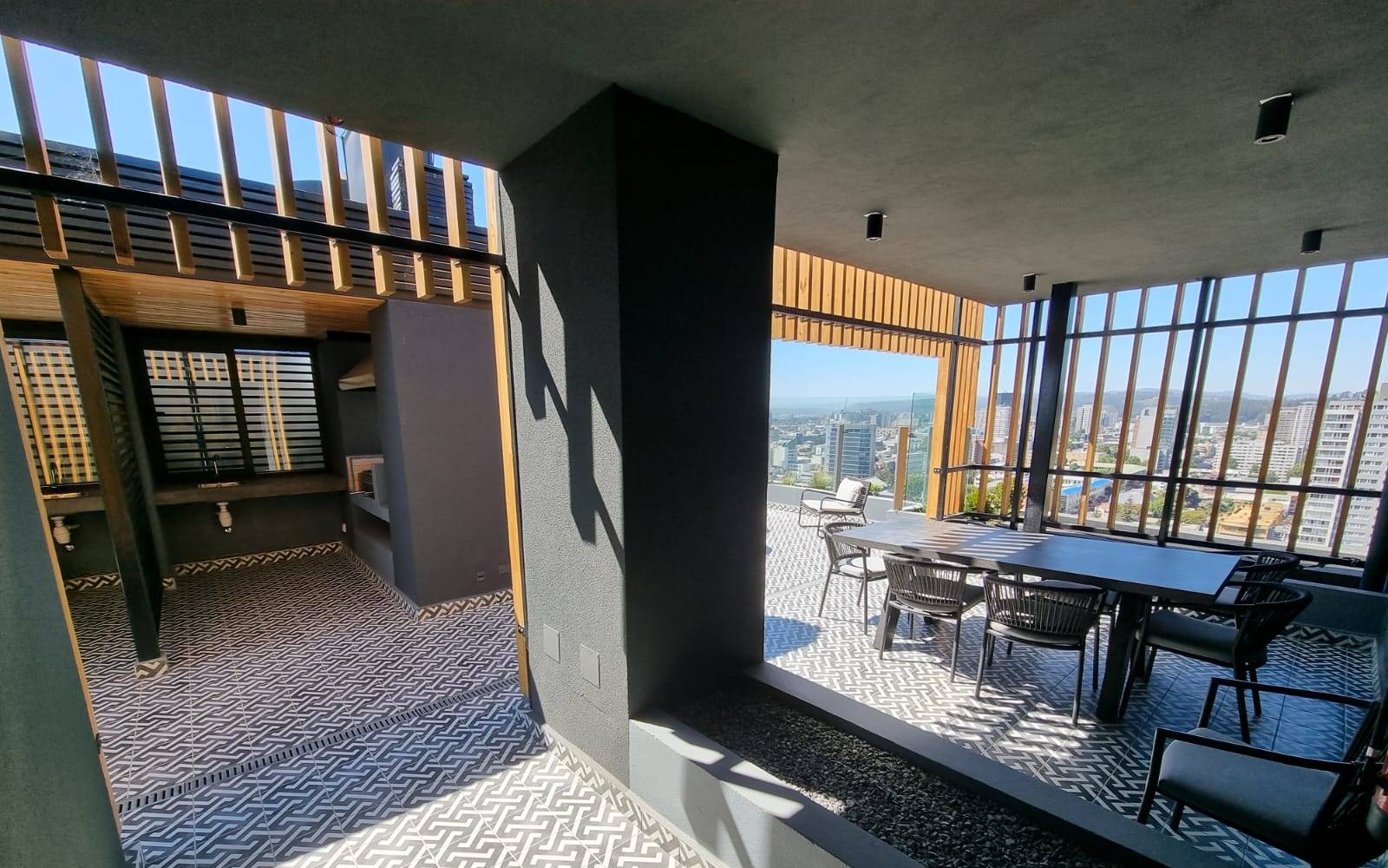 Terraza común con mesa comedor y vista a la ciudad