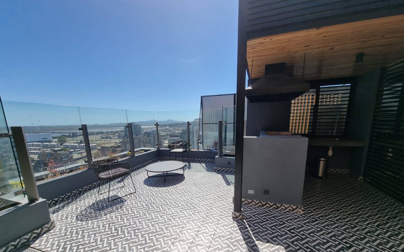Área de terraza exterior con barandas de cristal y vista