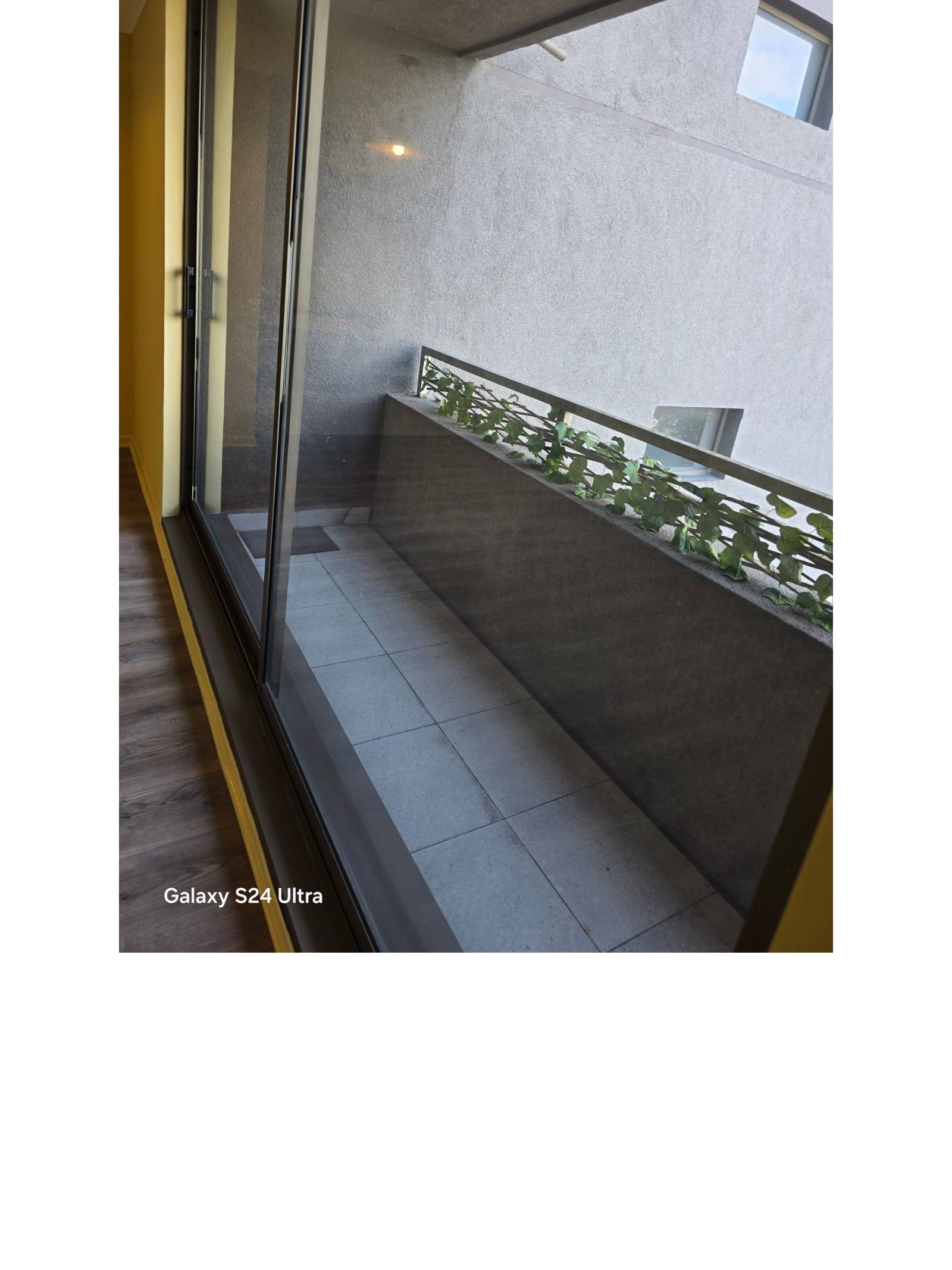 Balcón visto a través de ventanal corredizo