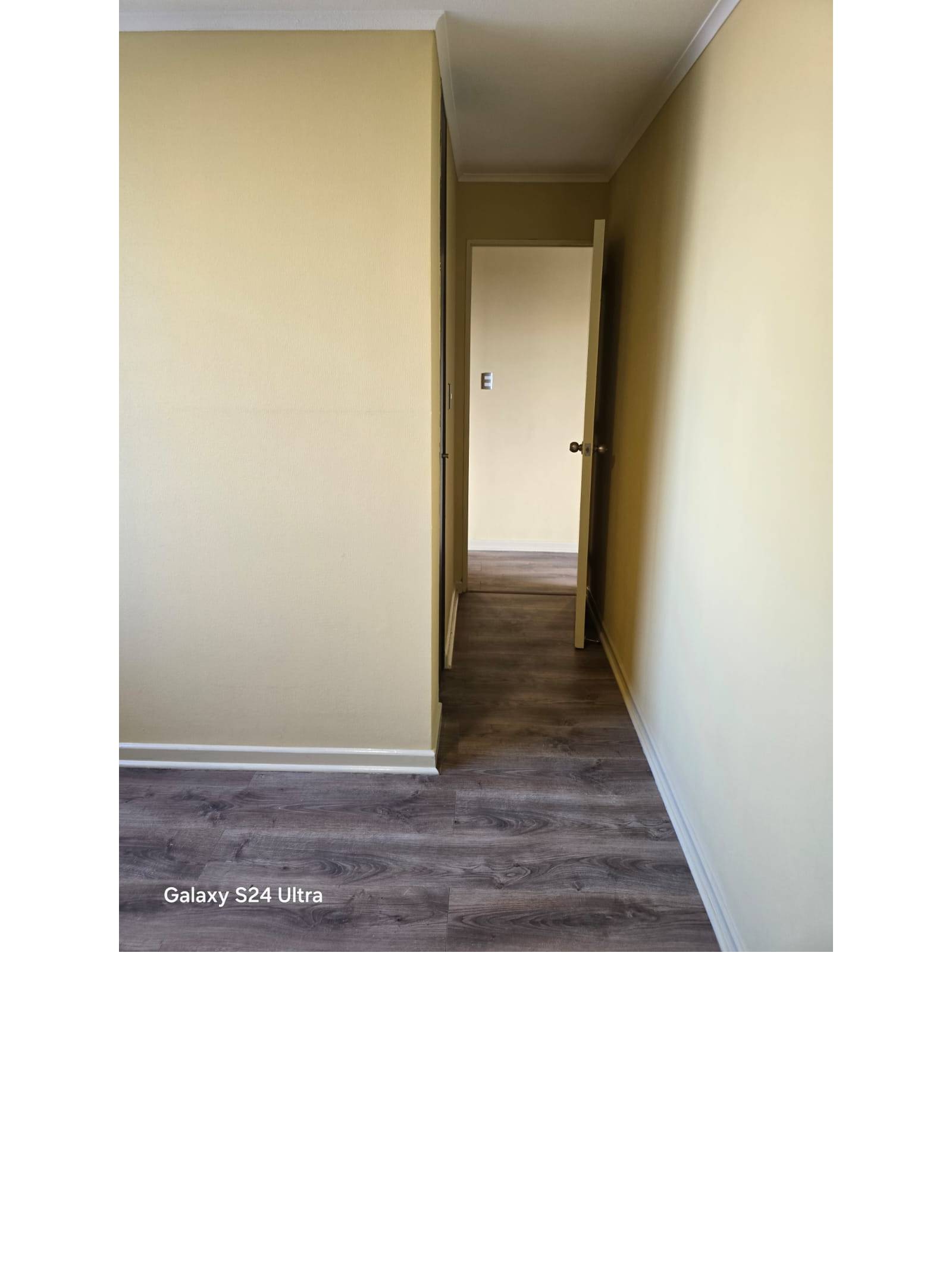 Pasillo estrecho con piso flotante y puertas interiores