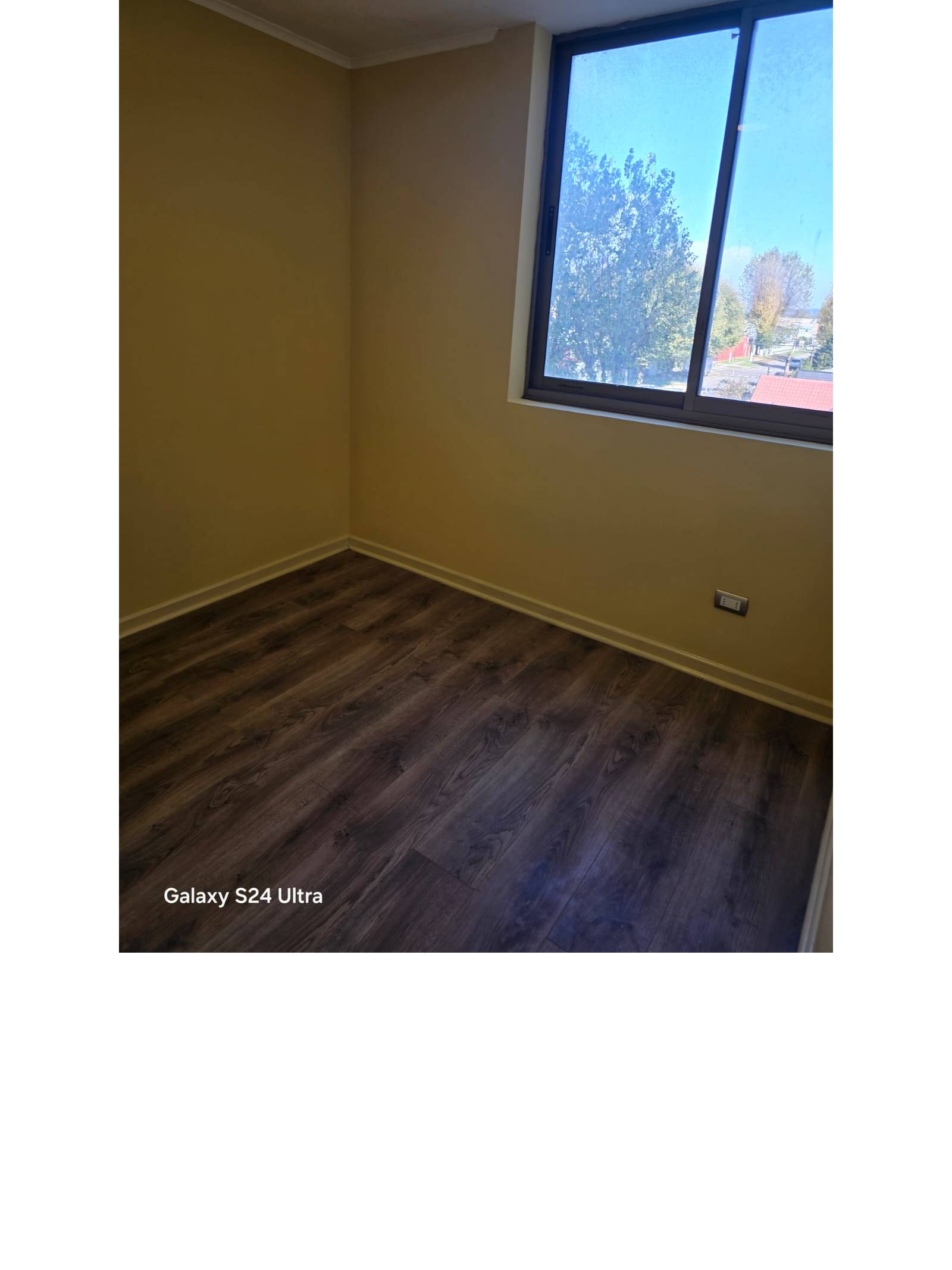 Dormitorio vacío con ventana y piso flotante