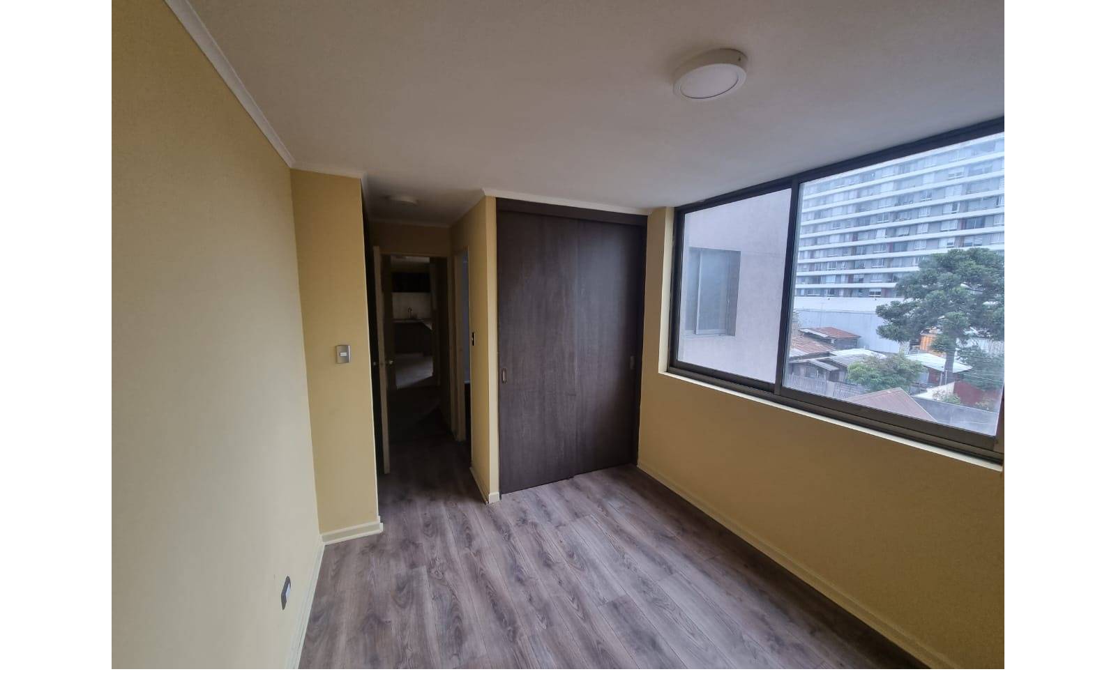 Dormitorio principal con clóset empotrado y ventanal amplio