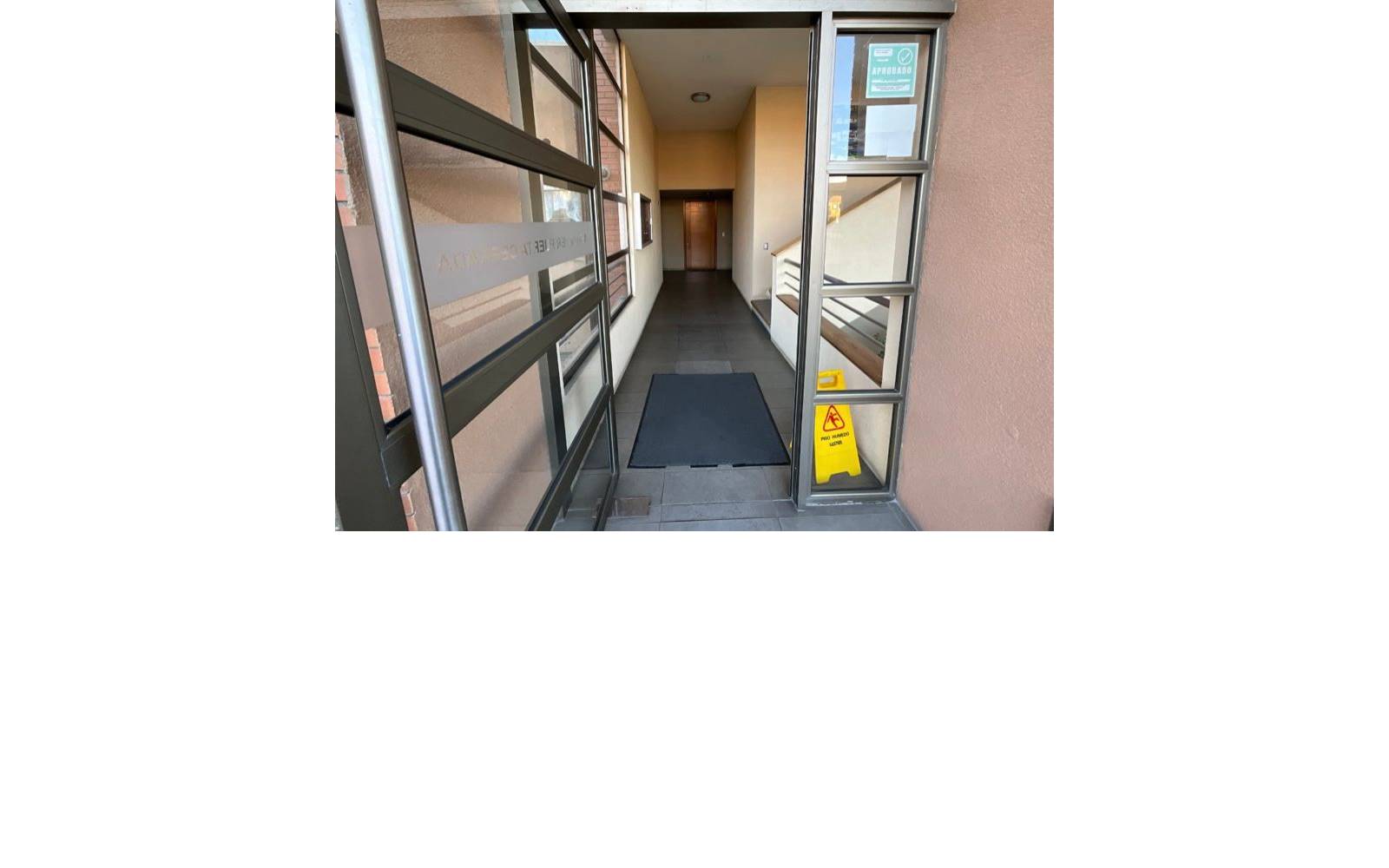 Acceso vidriado y pasillo de entrada al edificio