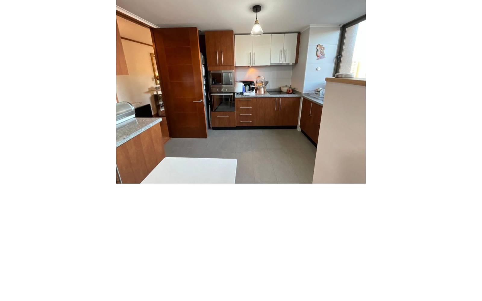 Cocina con muebles de madera y muros en blanco