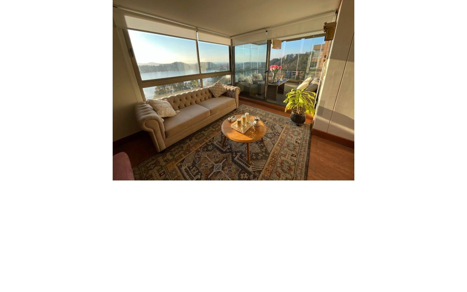 Living con sofá capitoné, ventanales amplios y vista despejada