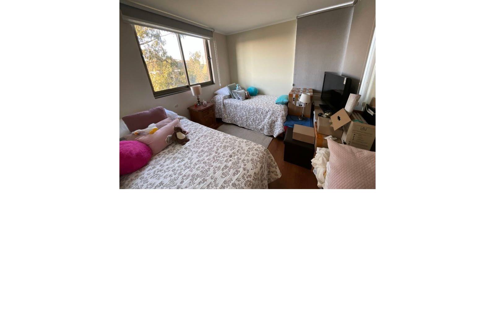 Dormitorio con dos camas individuales y ventana hacia el exterior