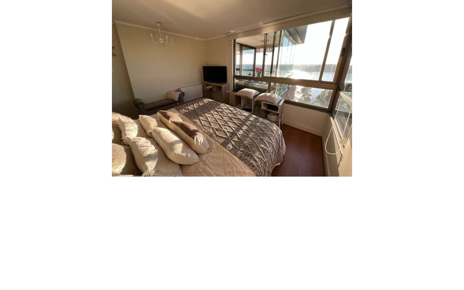 Dormitorio principal con cama matrimonial y ventanales con vista abierta