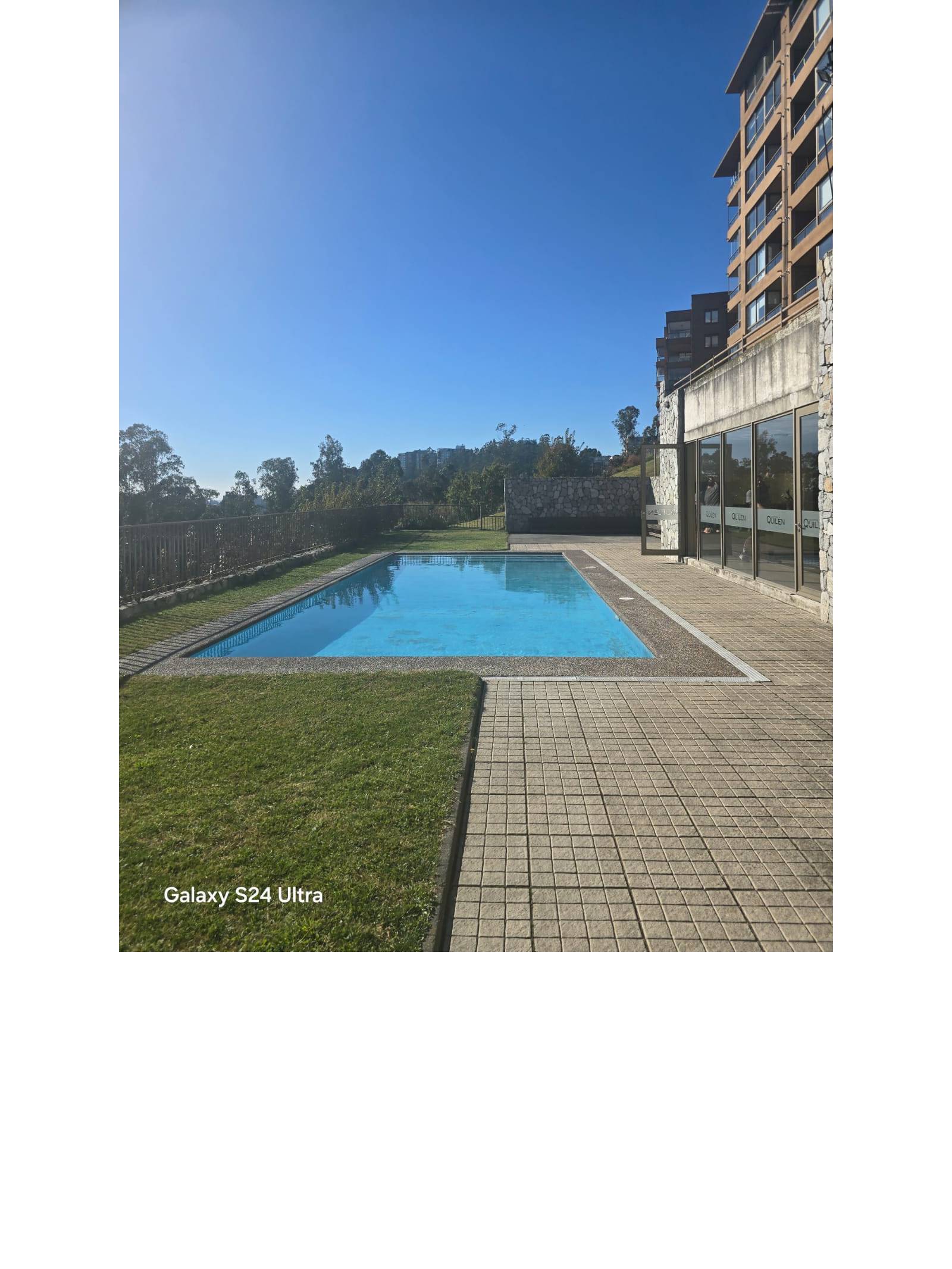 Piscina al aire libre con áreas verdes del condominio