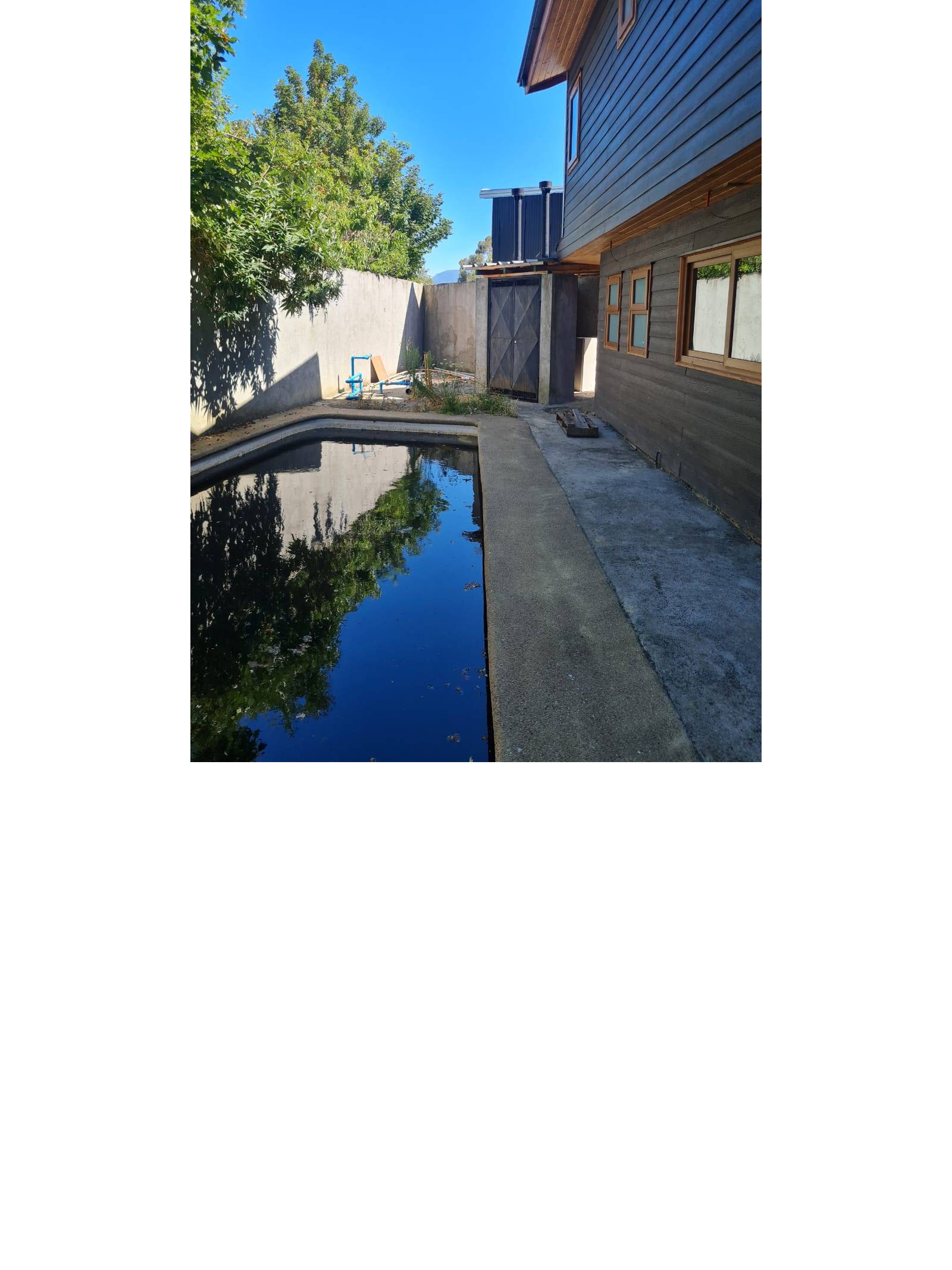 Patio exterior con piscina junto a la vivienda.