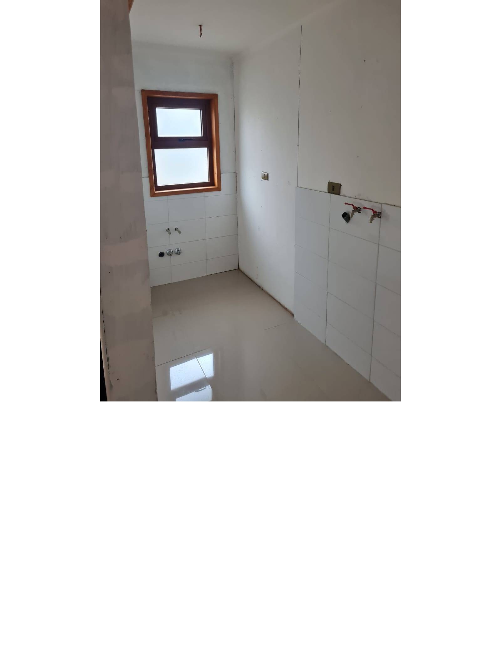 Habitación de lavandería con conexiones de agua y ventana.