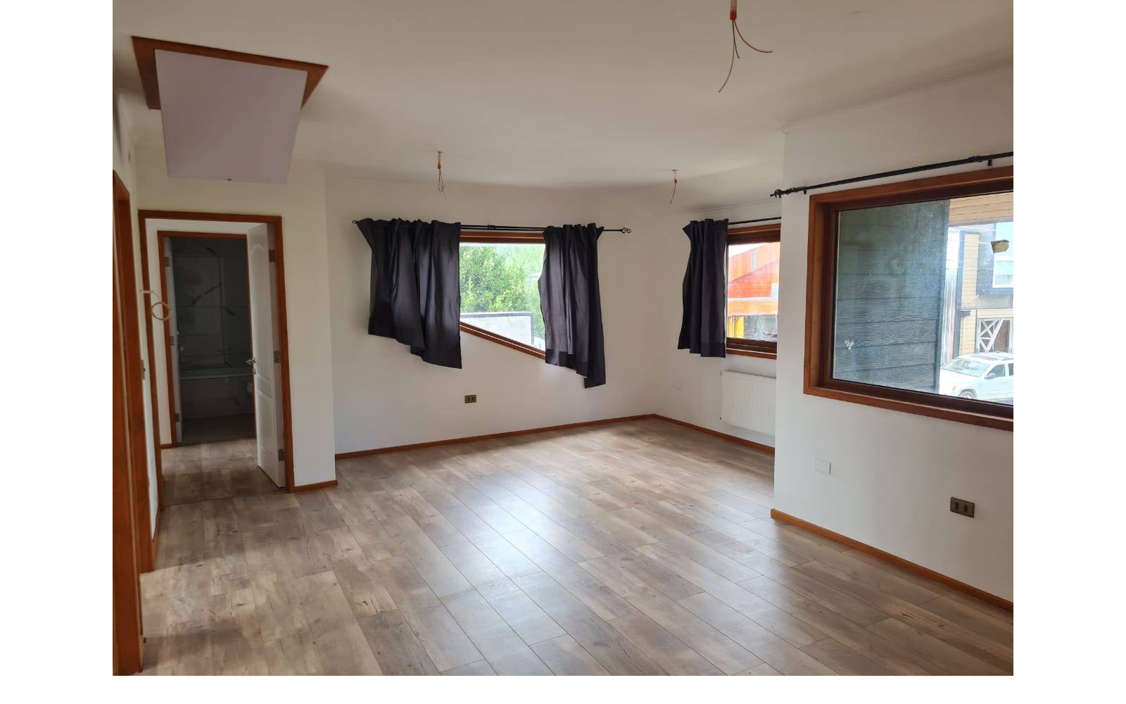 Dormitorio principal amplio con múltiples ventanas y piso flotante.