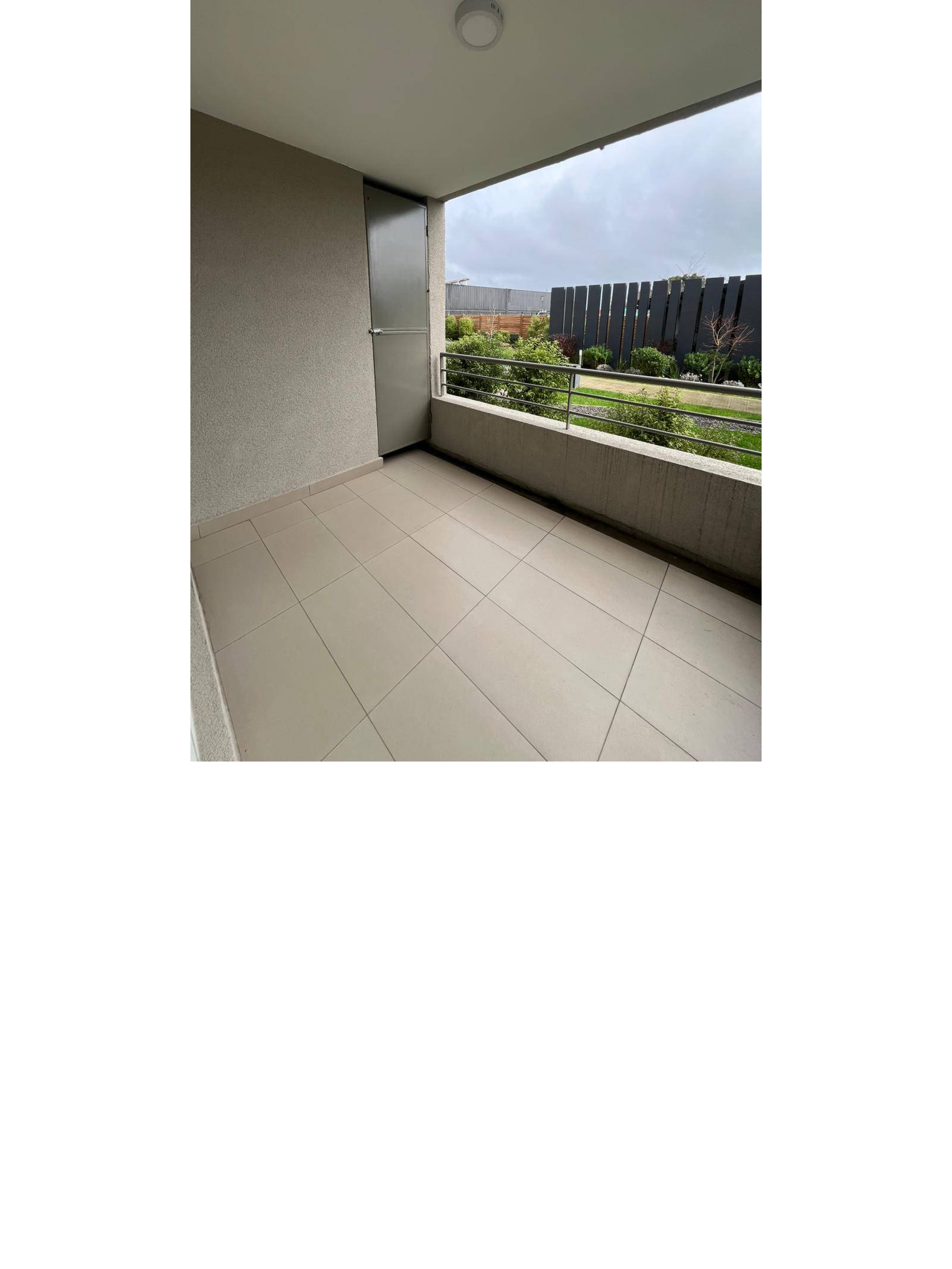 Terraza techada con piso cerámico y vista hacia el jardín