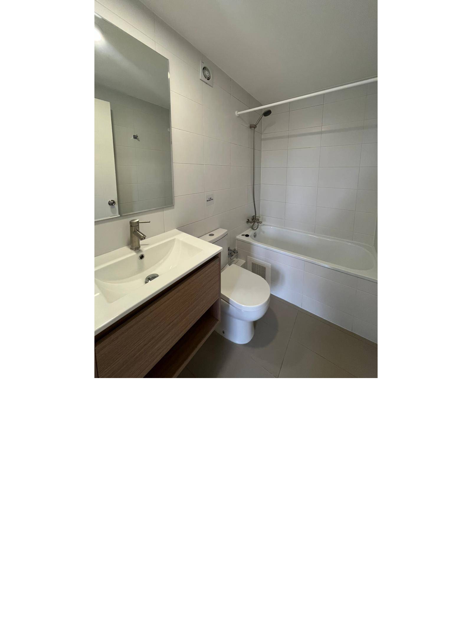 Baño completo con tina, vanitorio flotante y espejo amplio
