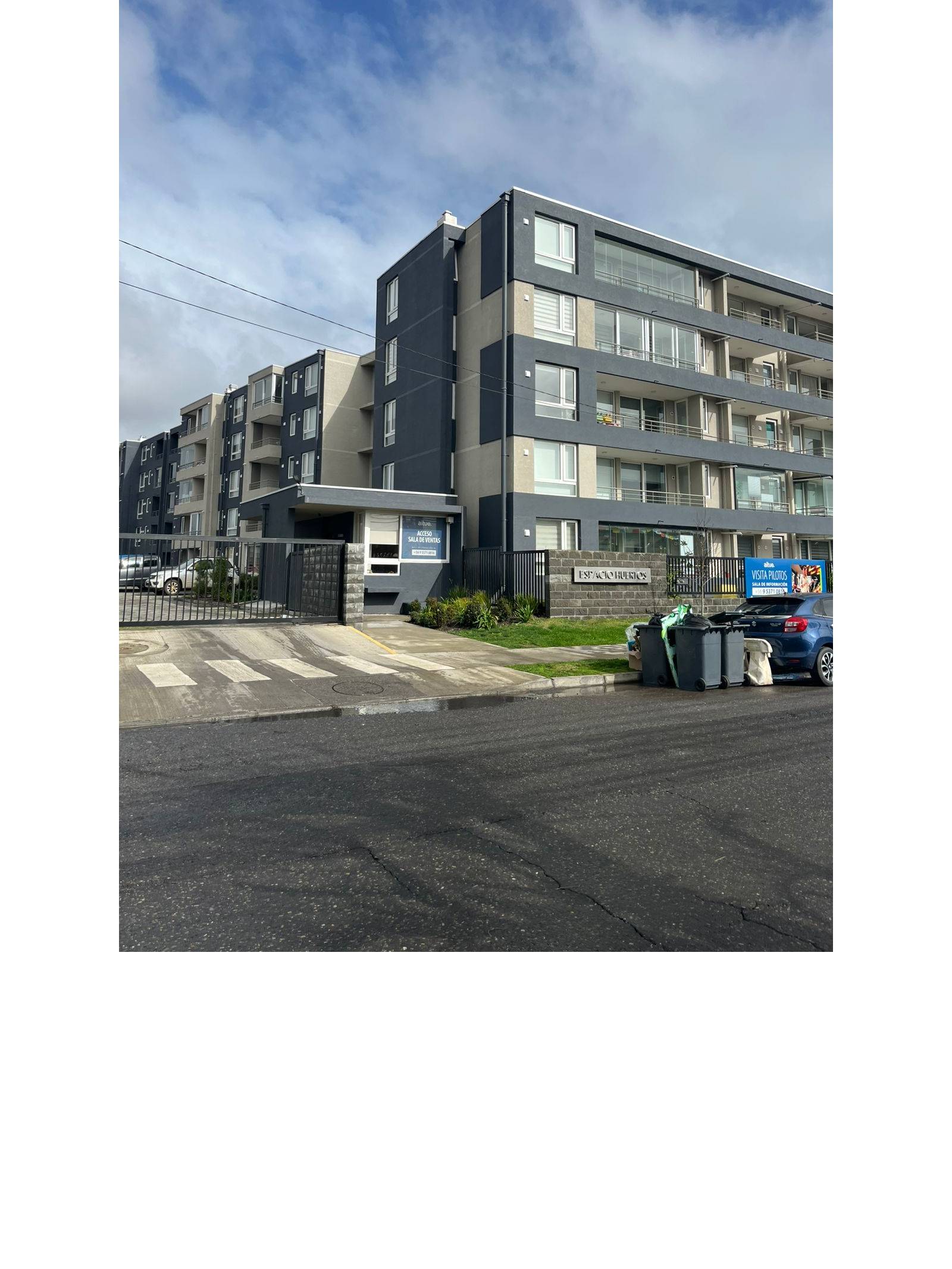 Fachada exterior del edificio residencial con portón de acceso