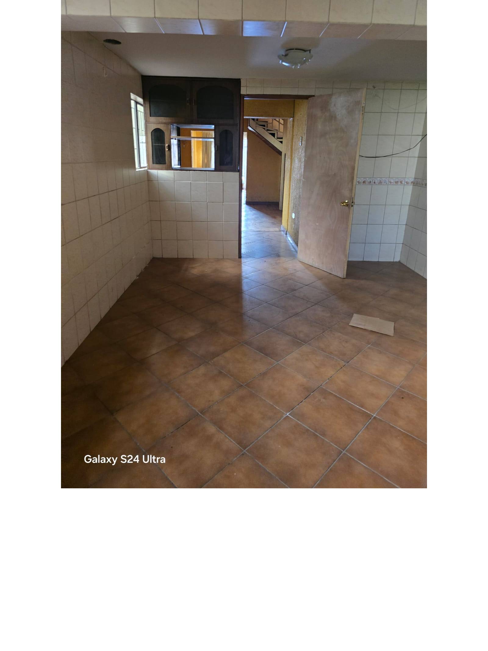 Espacio interior con piso cerámico y paredes con azulejos claros.