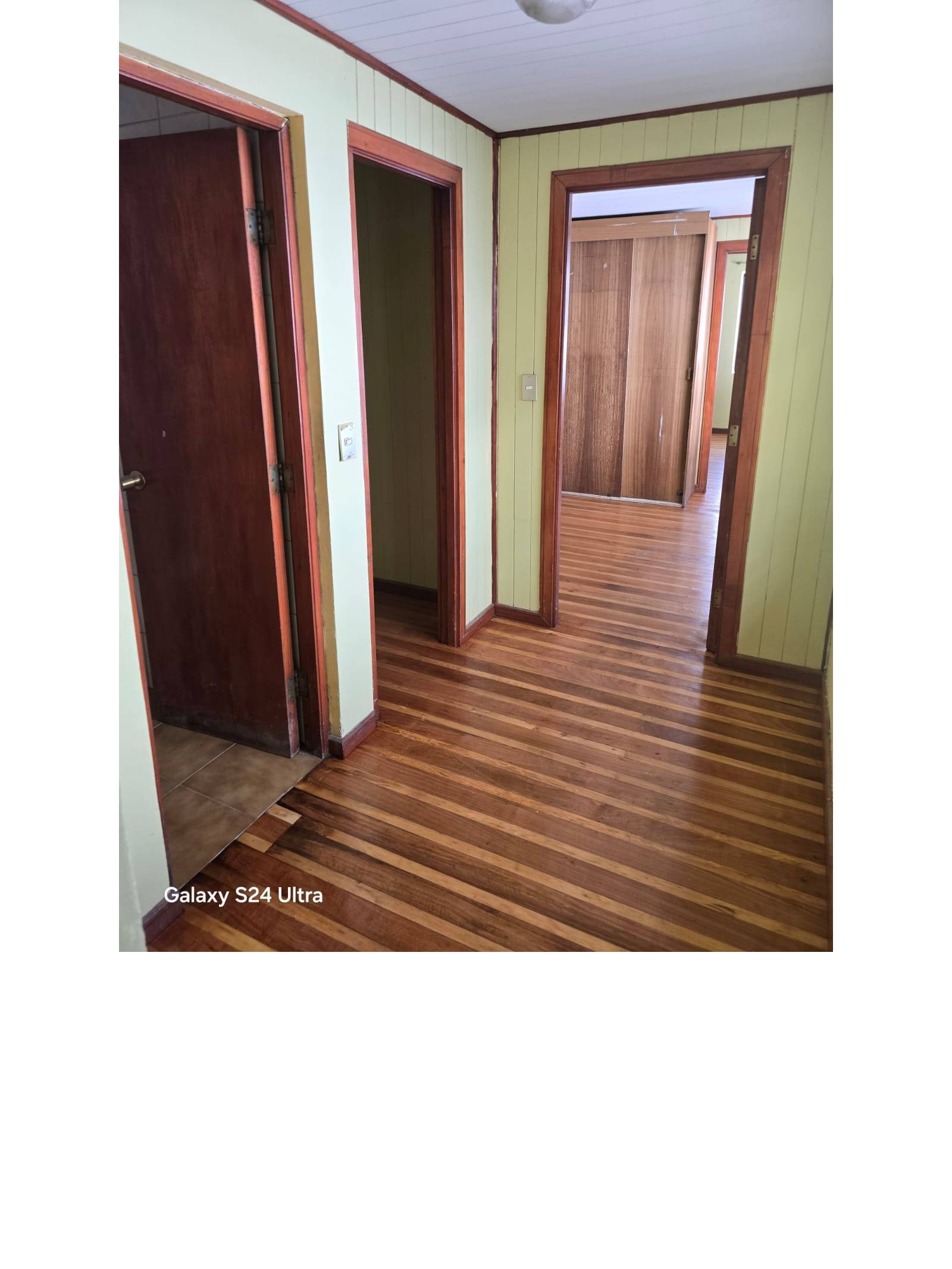 Hall de distribución en segundo piso con puertas a dormitorios.