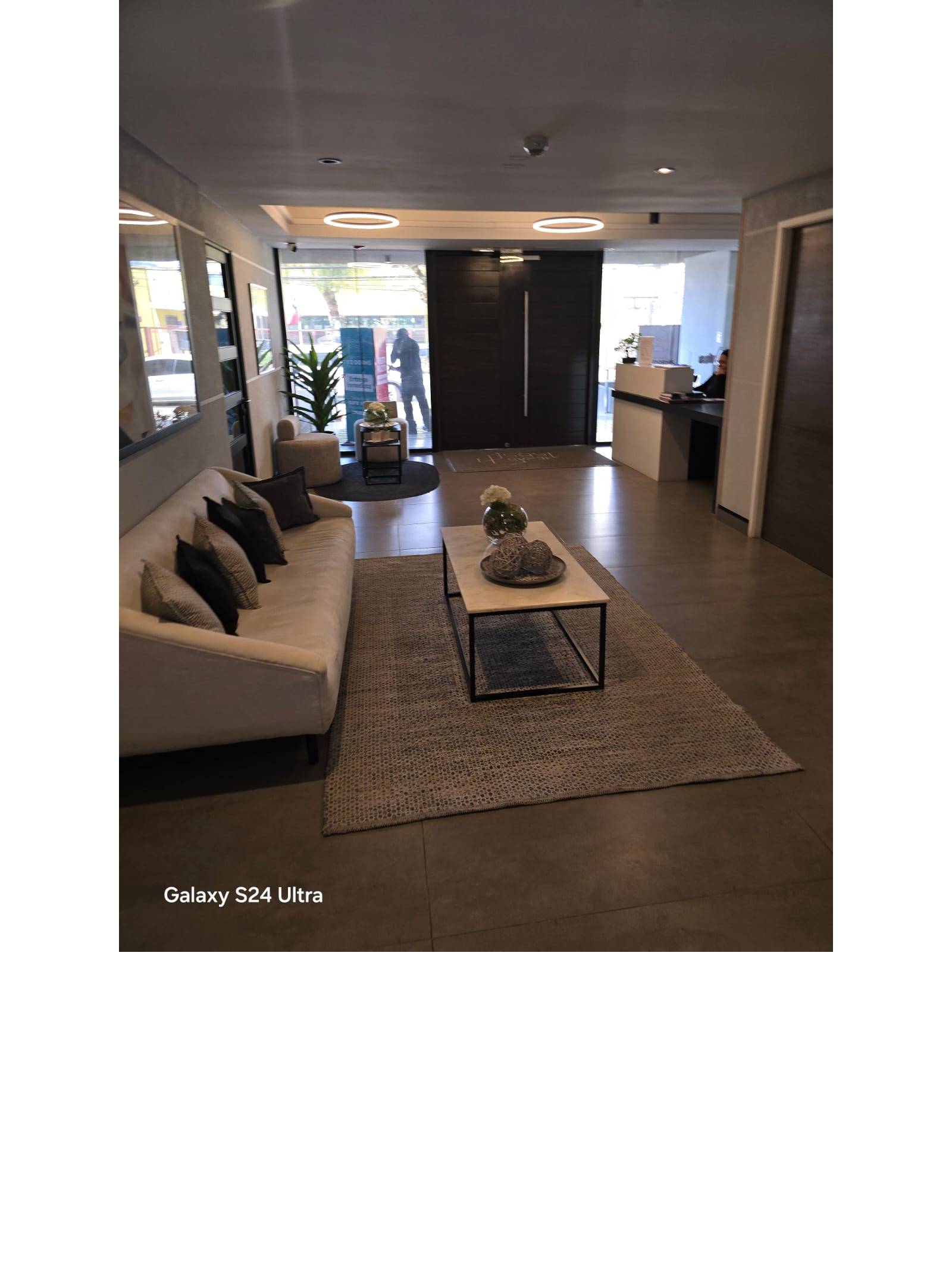 Hall de acceso y recepción con sillones y mesa de centro.