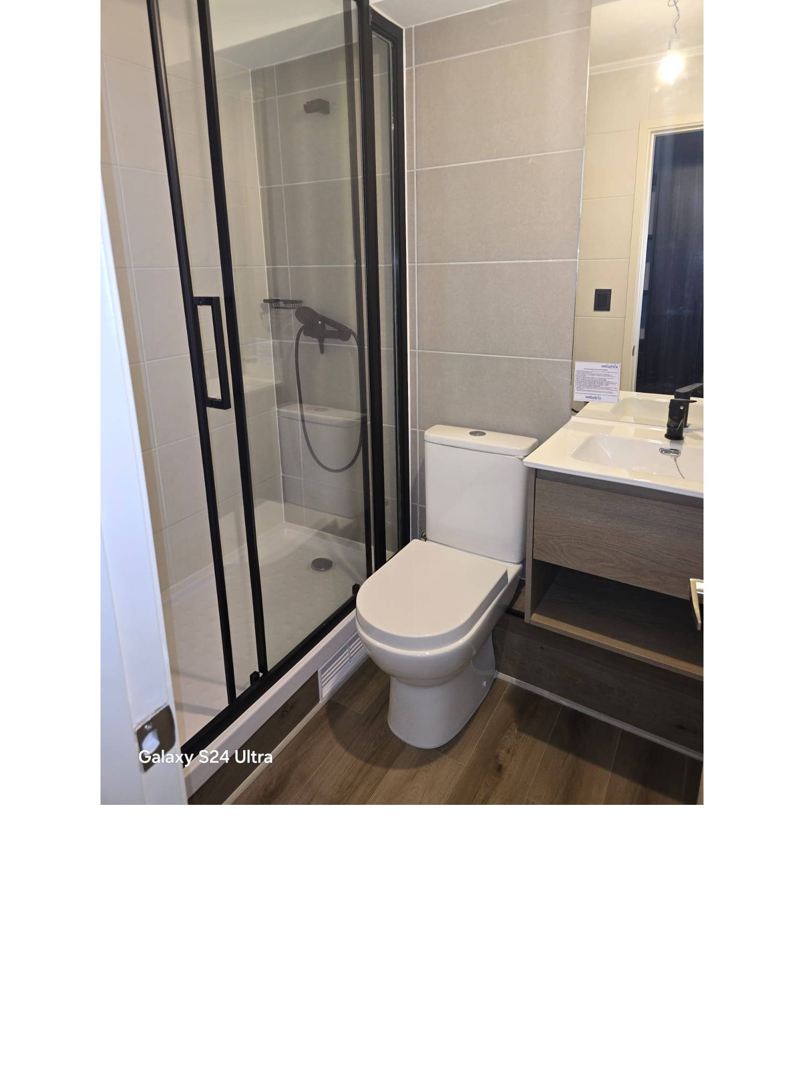 Baño con shower door de vidrio y vanitorio moderno.
