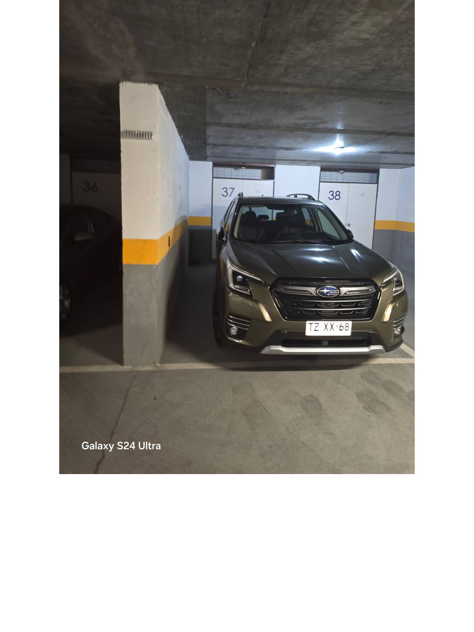 Estacionamiento subterráneo numerado con vehículo aparcado.