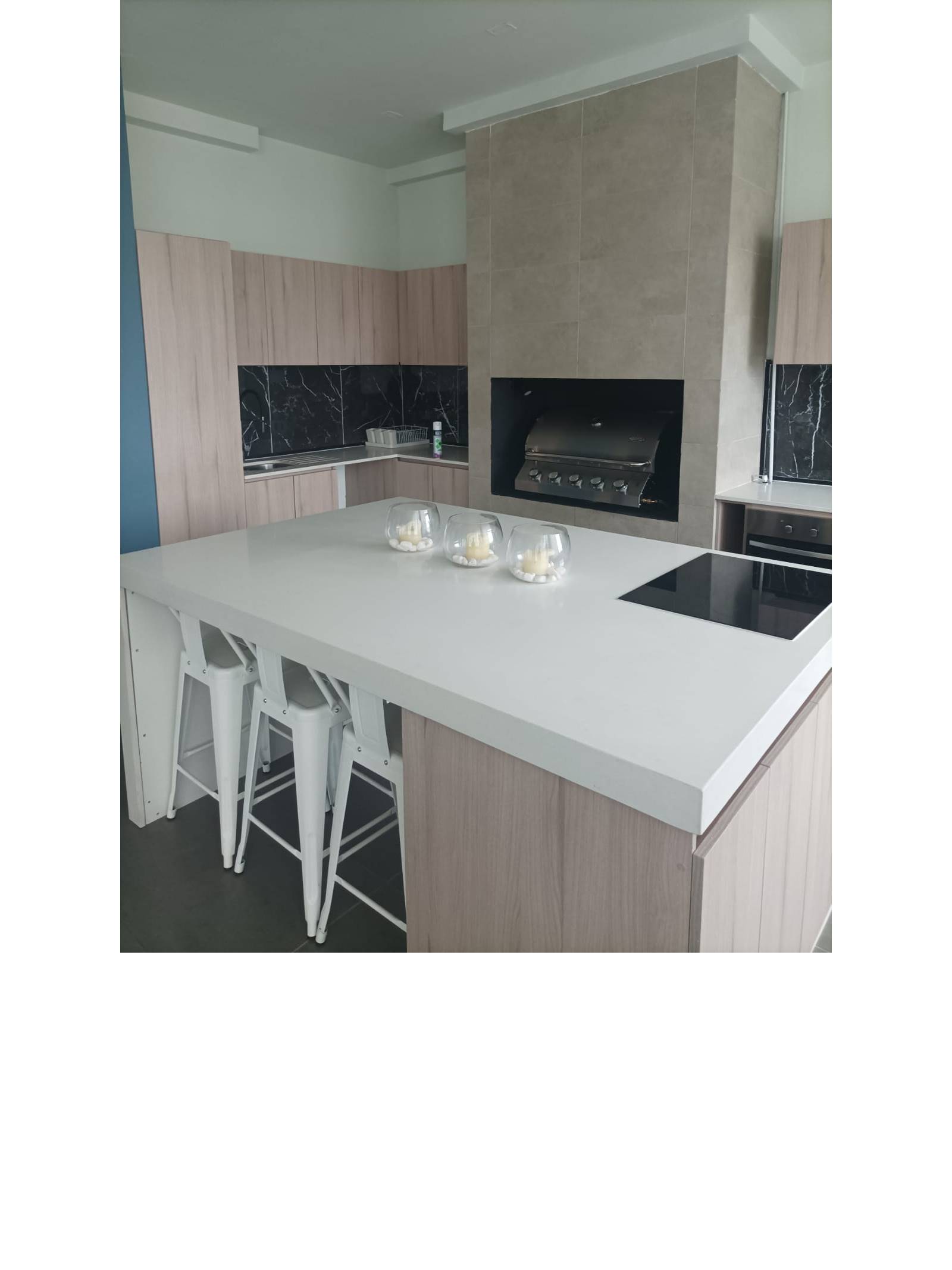 Mesón con encimera y parrilla en quincho interior.