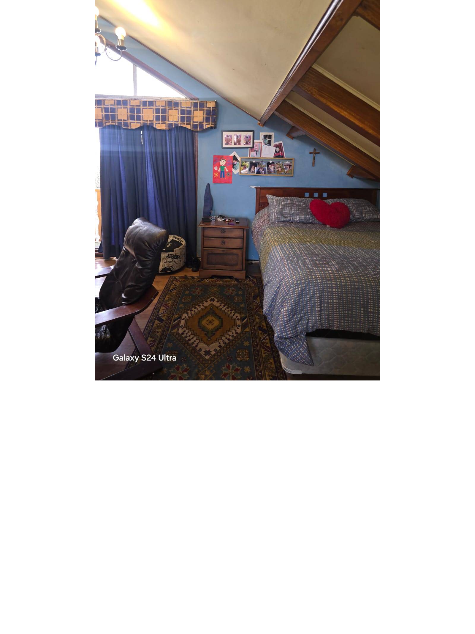 Dormitorio abuhardillado con vigas a la vista
