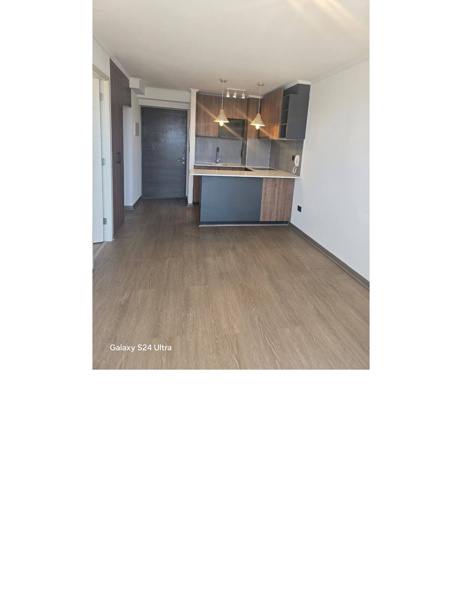 Espacio integrado de estar y cocina americana con piso flotante.