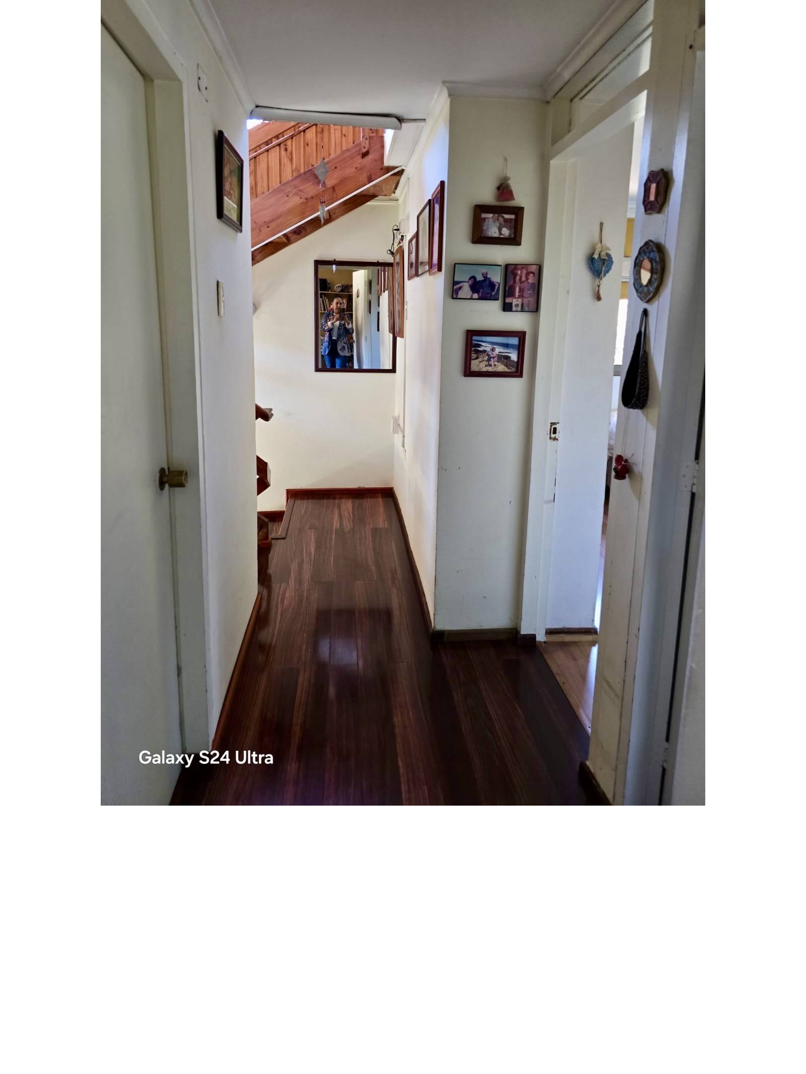 Pasillo interior con piso de madera y escalera