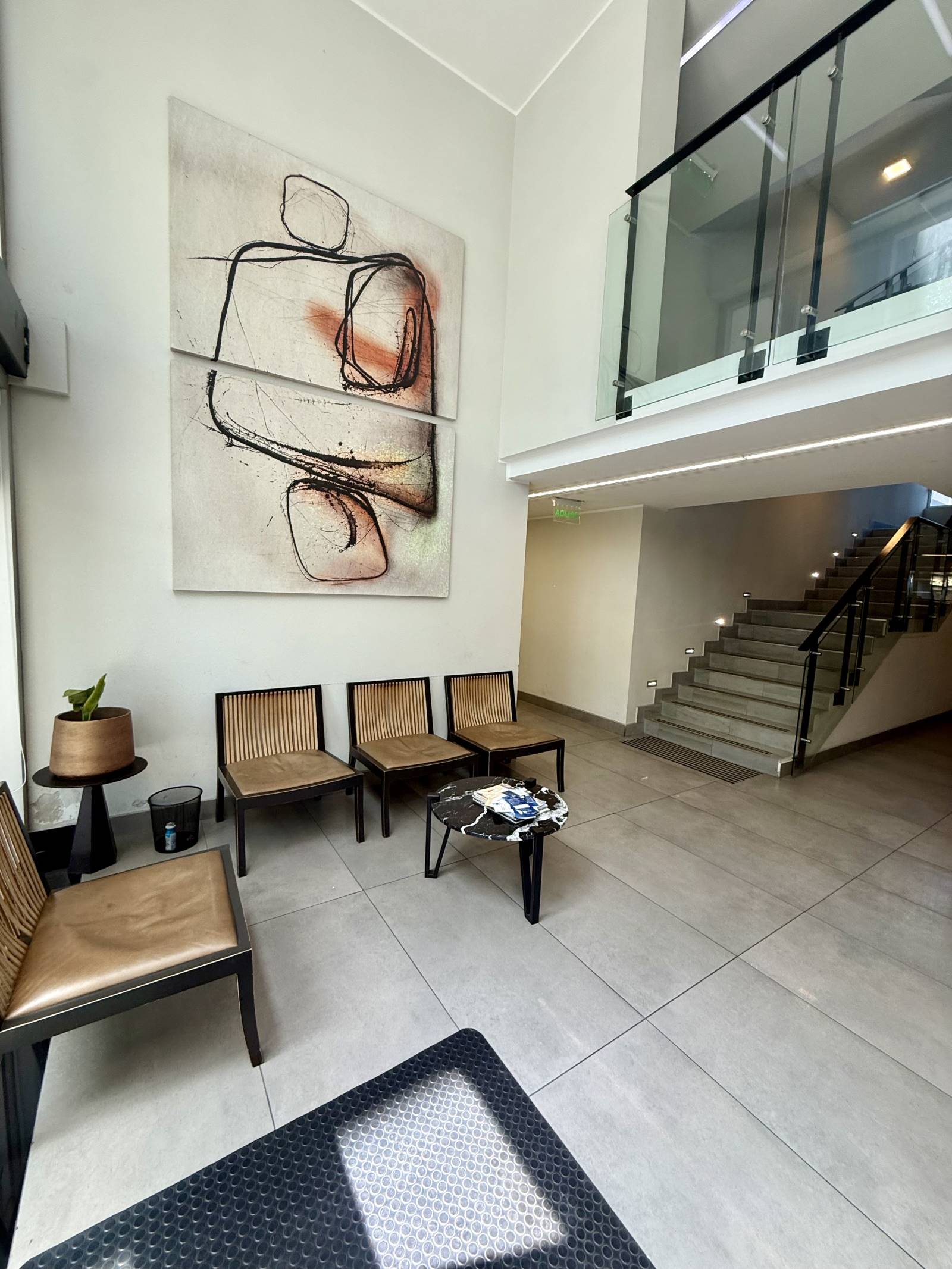Hall de acceso con sala de espera y cuadro artístico decorativo.