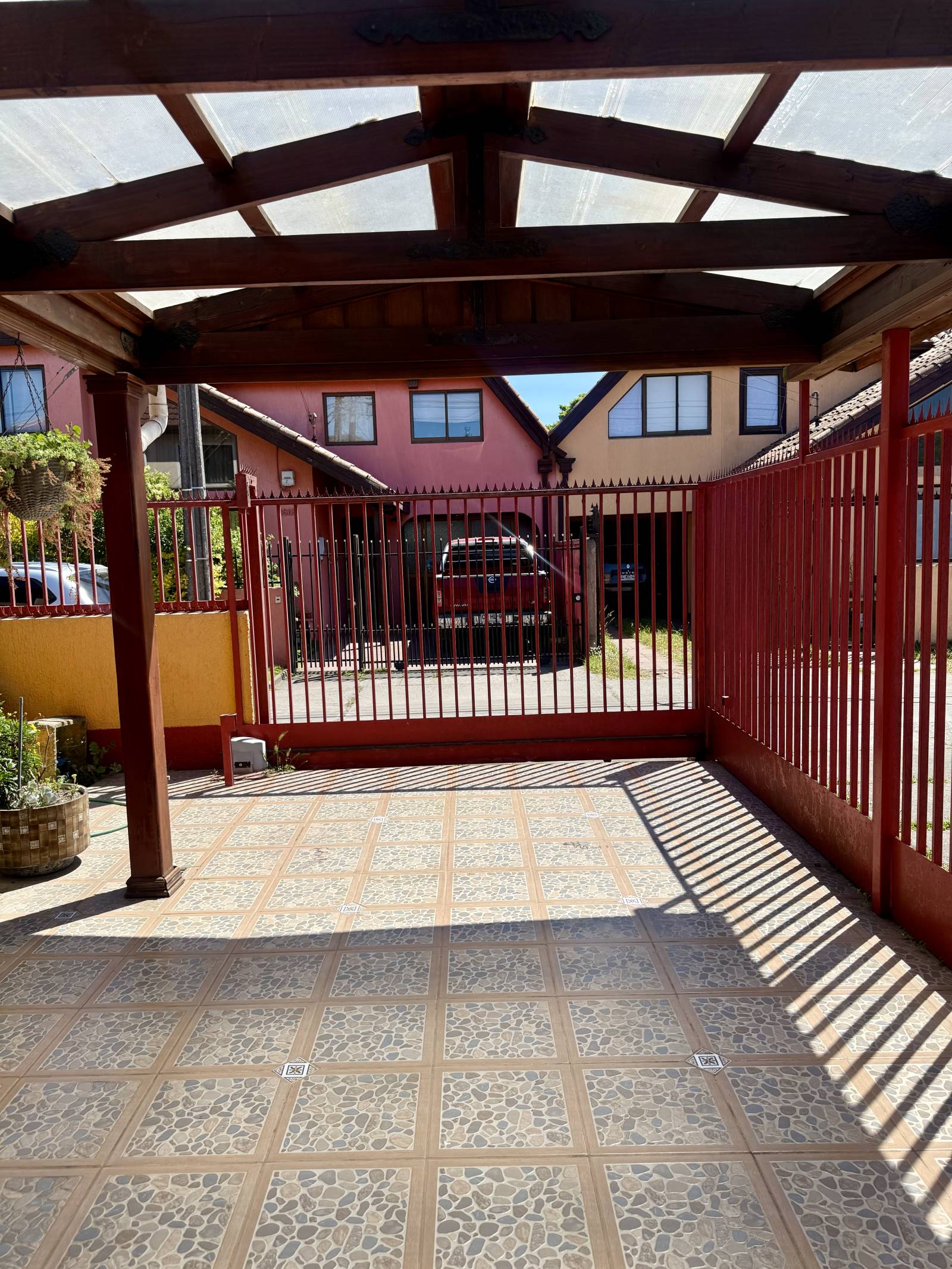 Entrada vehicular techada con portón metálico de corredera