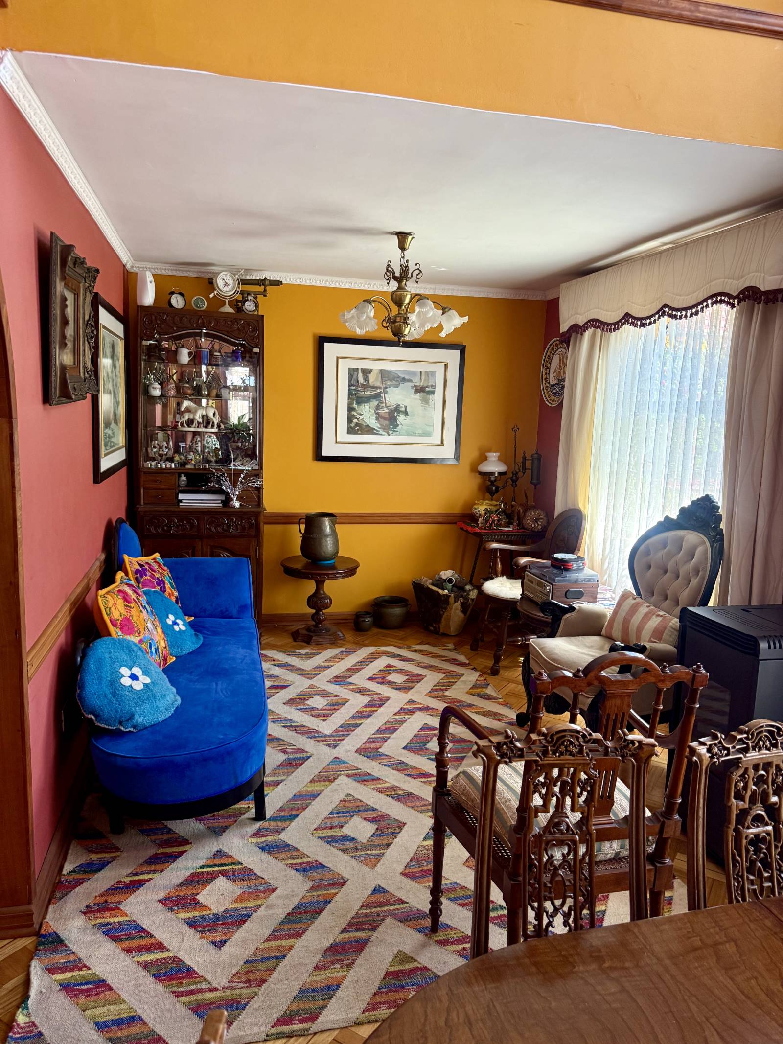Living amoblado con sillones, alfombra geométrica y cuadros