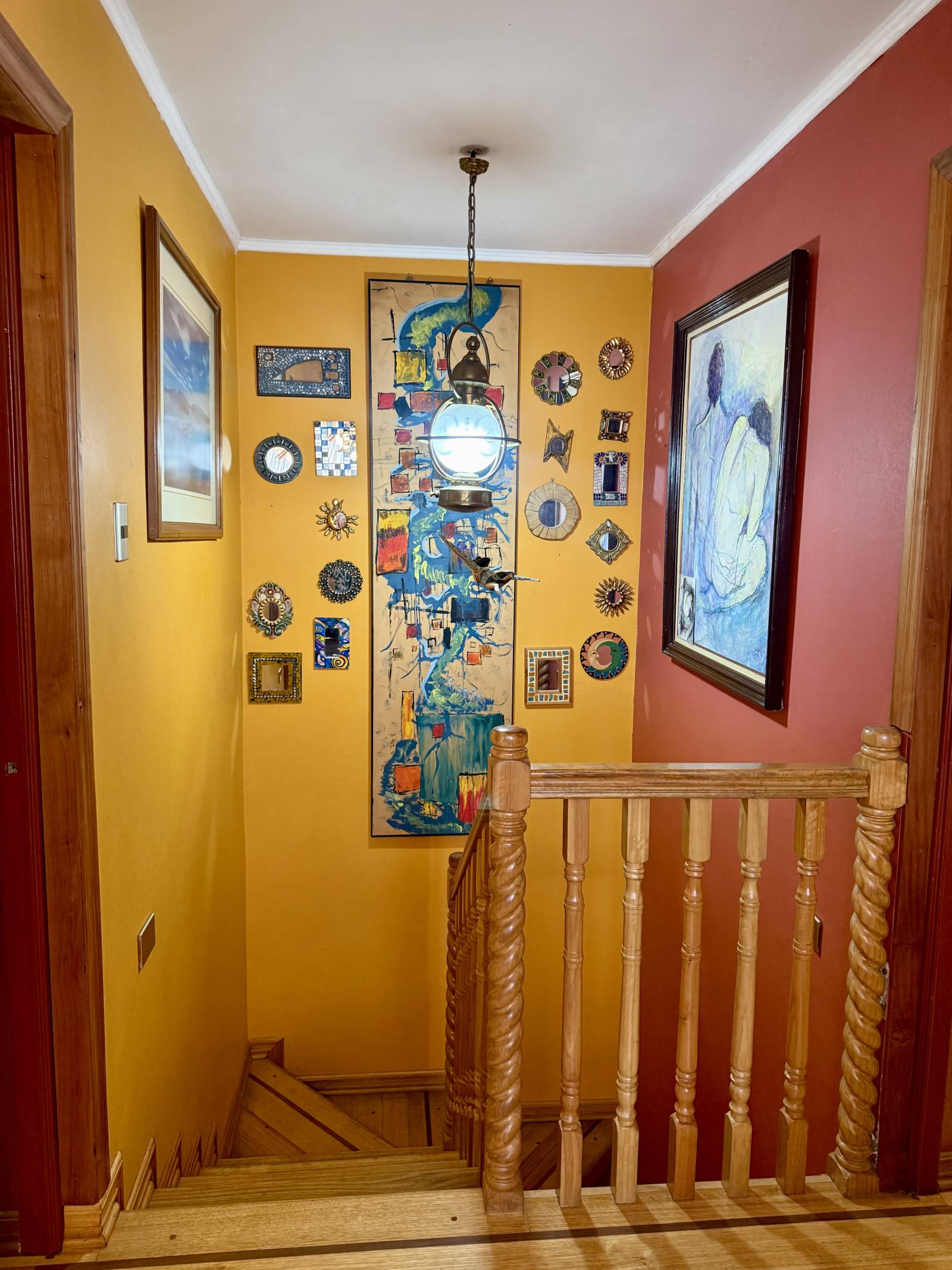 Caja de escala con baranda de madera y muros decorados