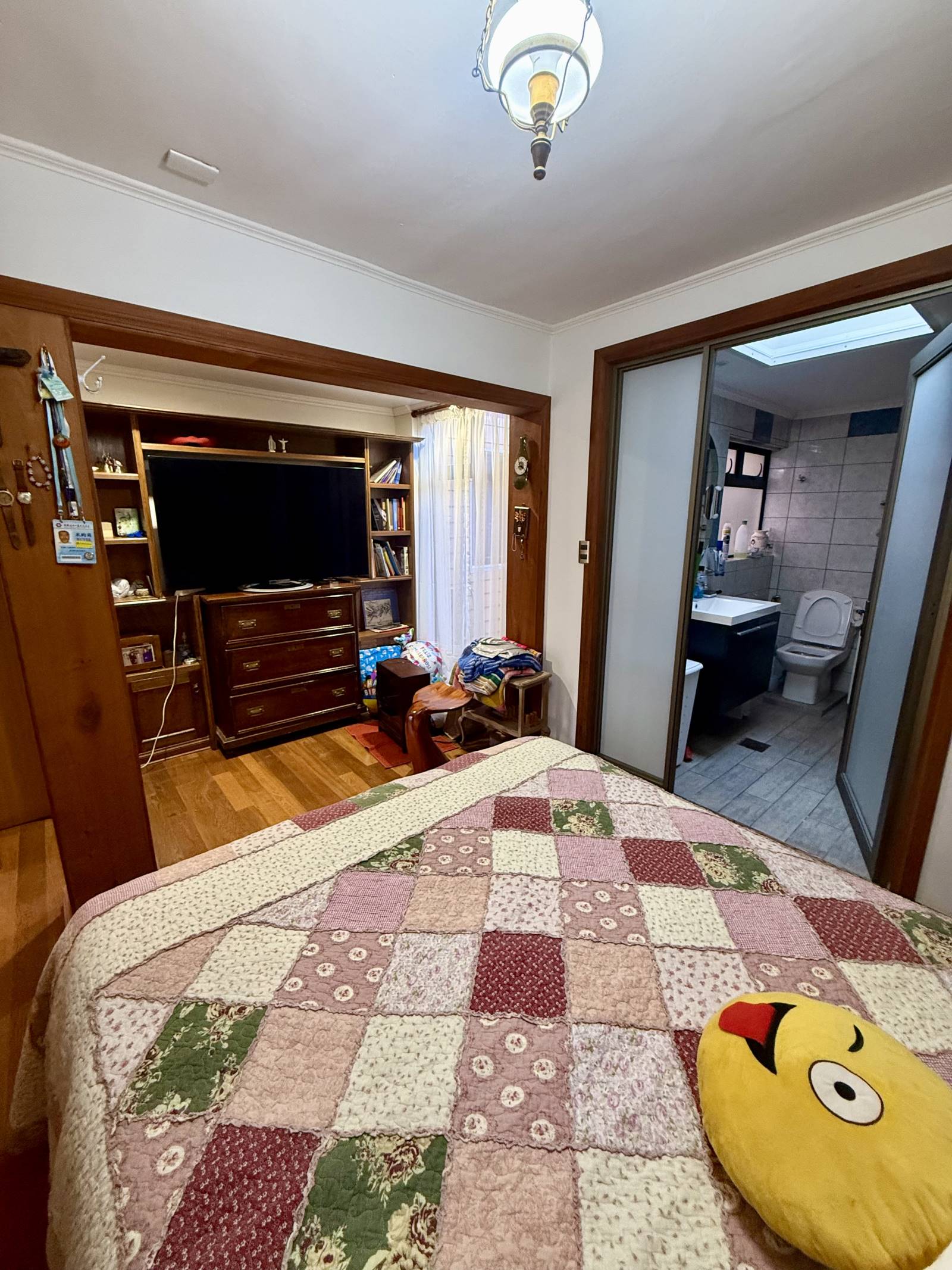 Dormitorio con mueble de televisión y baño en suite