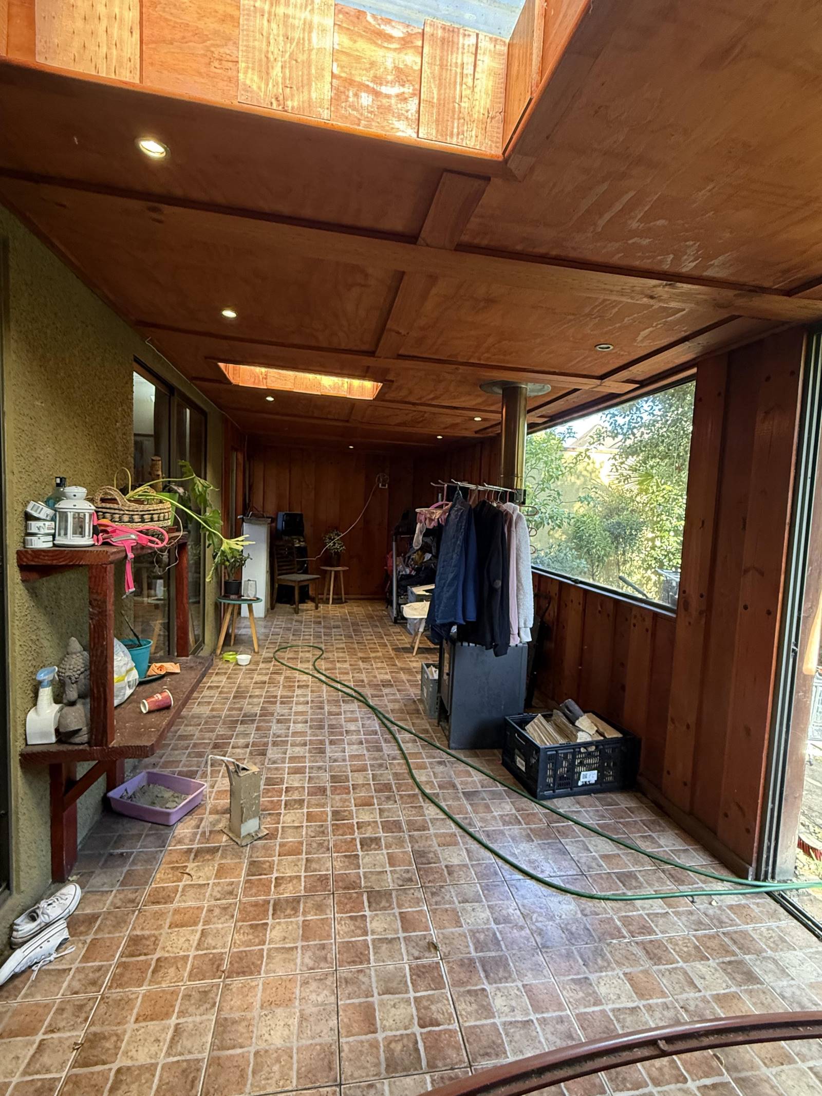 Amplia terraza techada en madera con piso cerámico rústico.