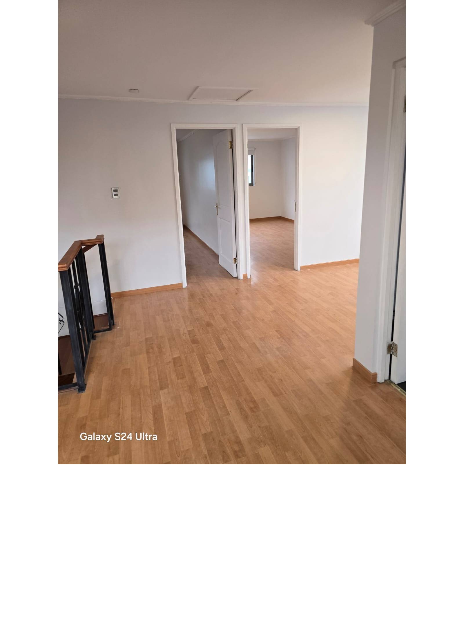 Hall de distribución en segundo piso con puertas a dormitorios.