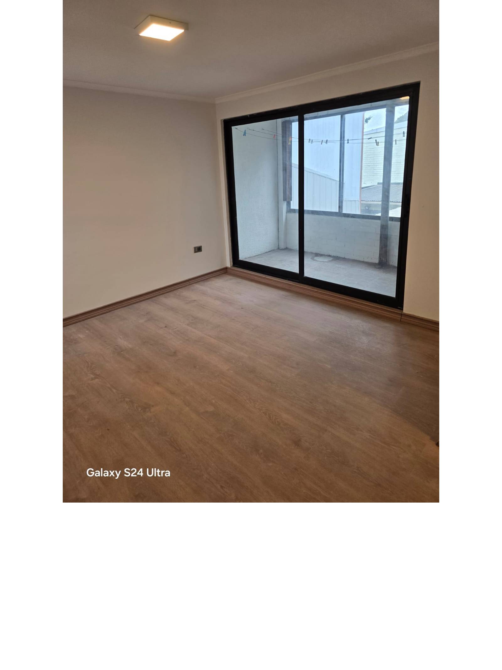 Dormitorio principal con ventanal corredero hacia patio interior.