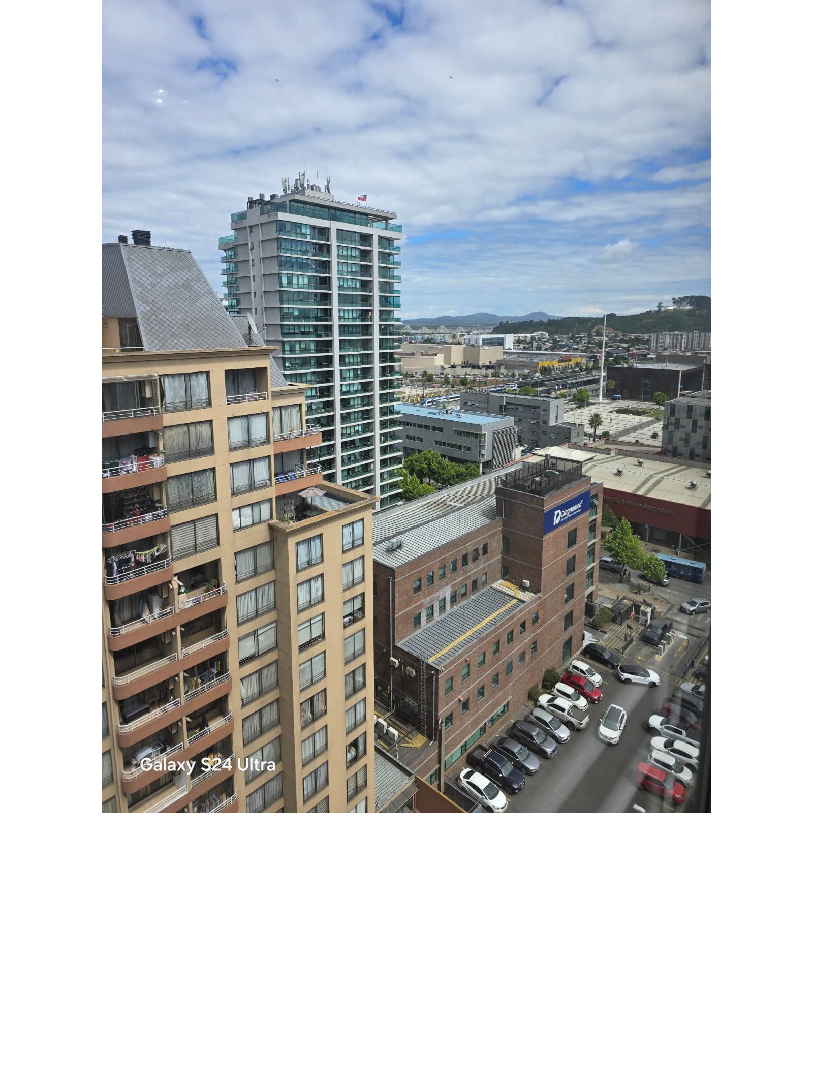 Panorámica urbana con edificios modernos y montañas lejanas