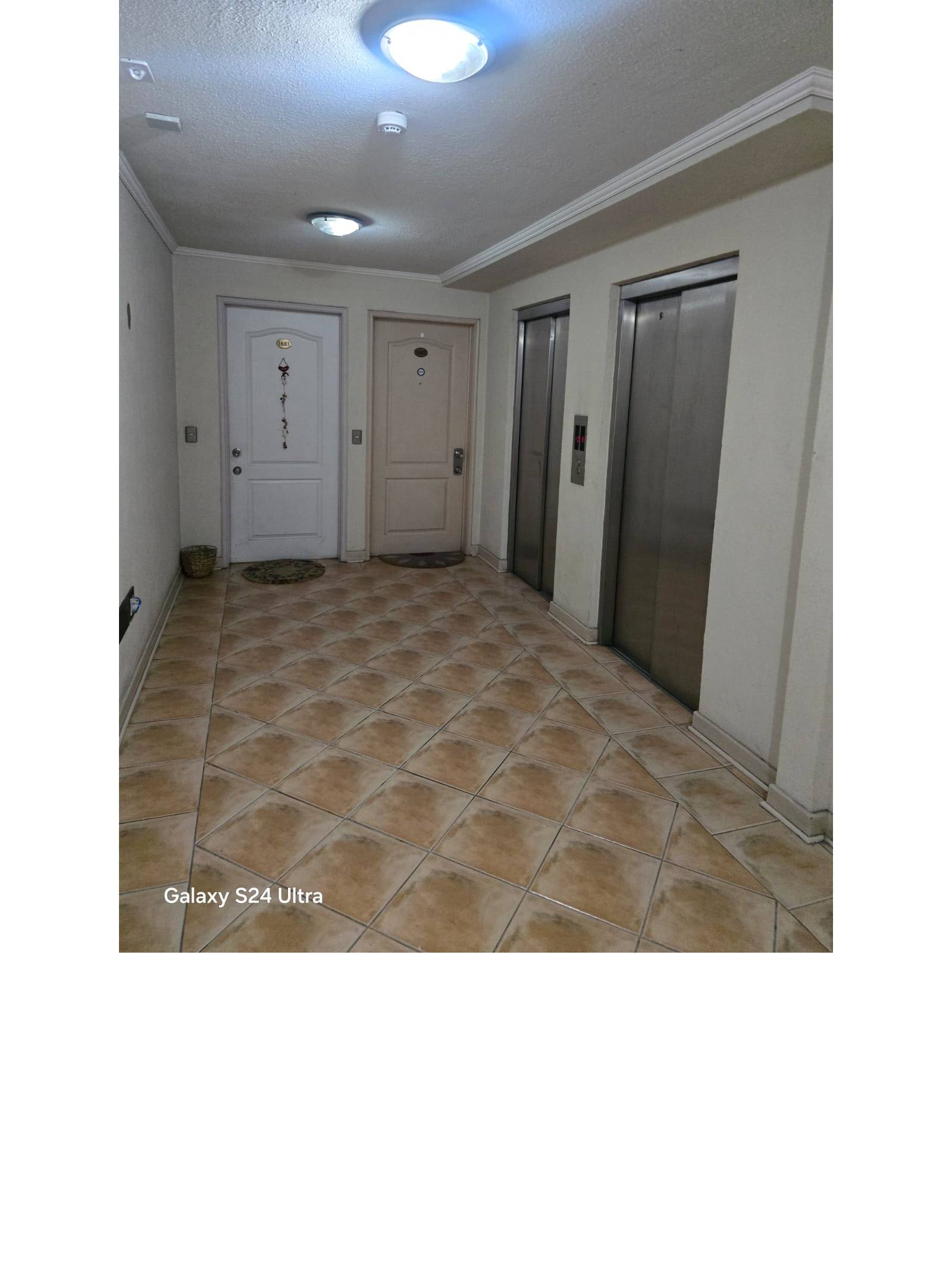 Hall común de acceso con ascensores y puertas de entrada