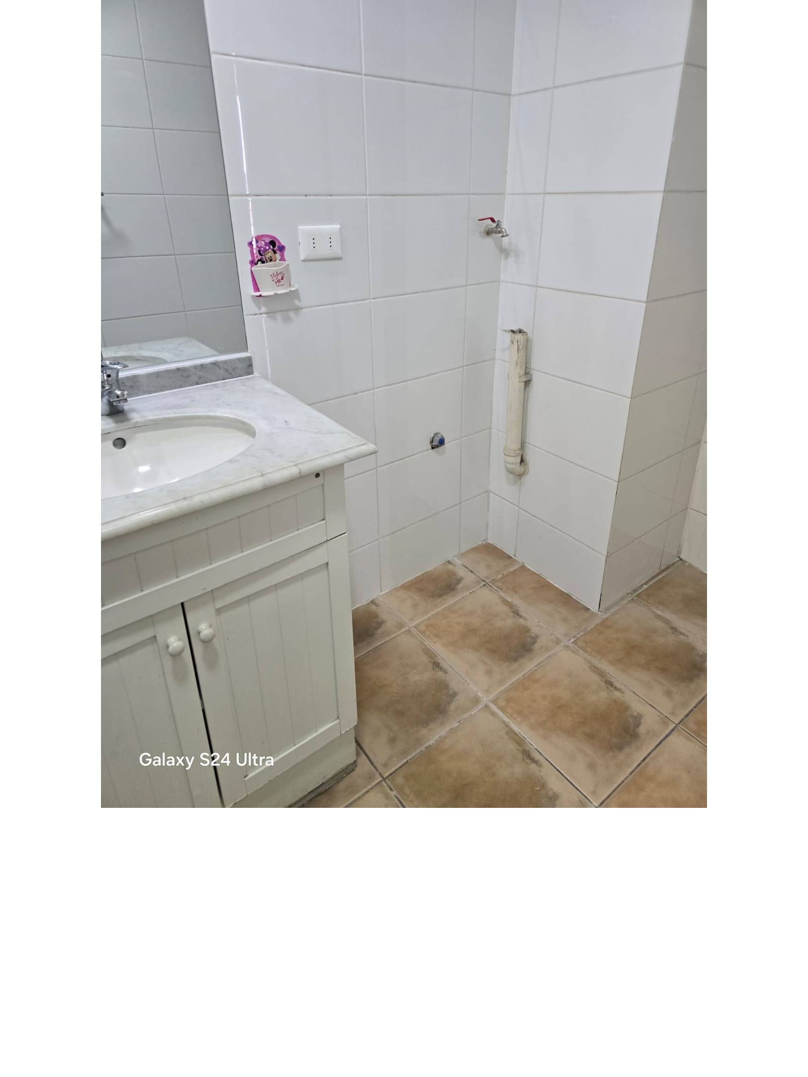 Conexión para lavadora junto al vanitorio del baño