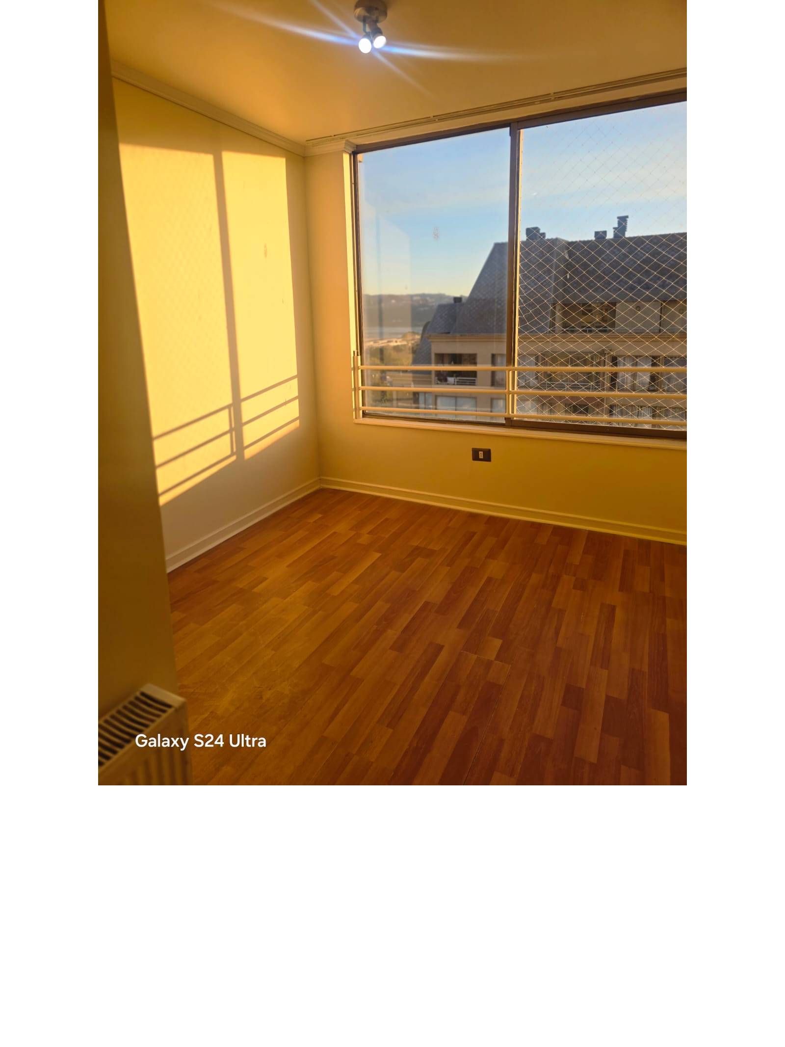 Dormitorio iluminado con ventanal y malla protectora