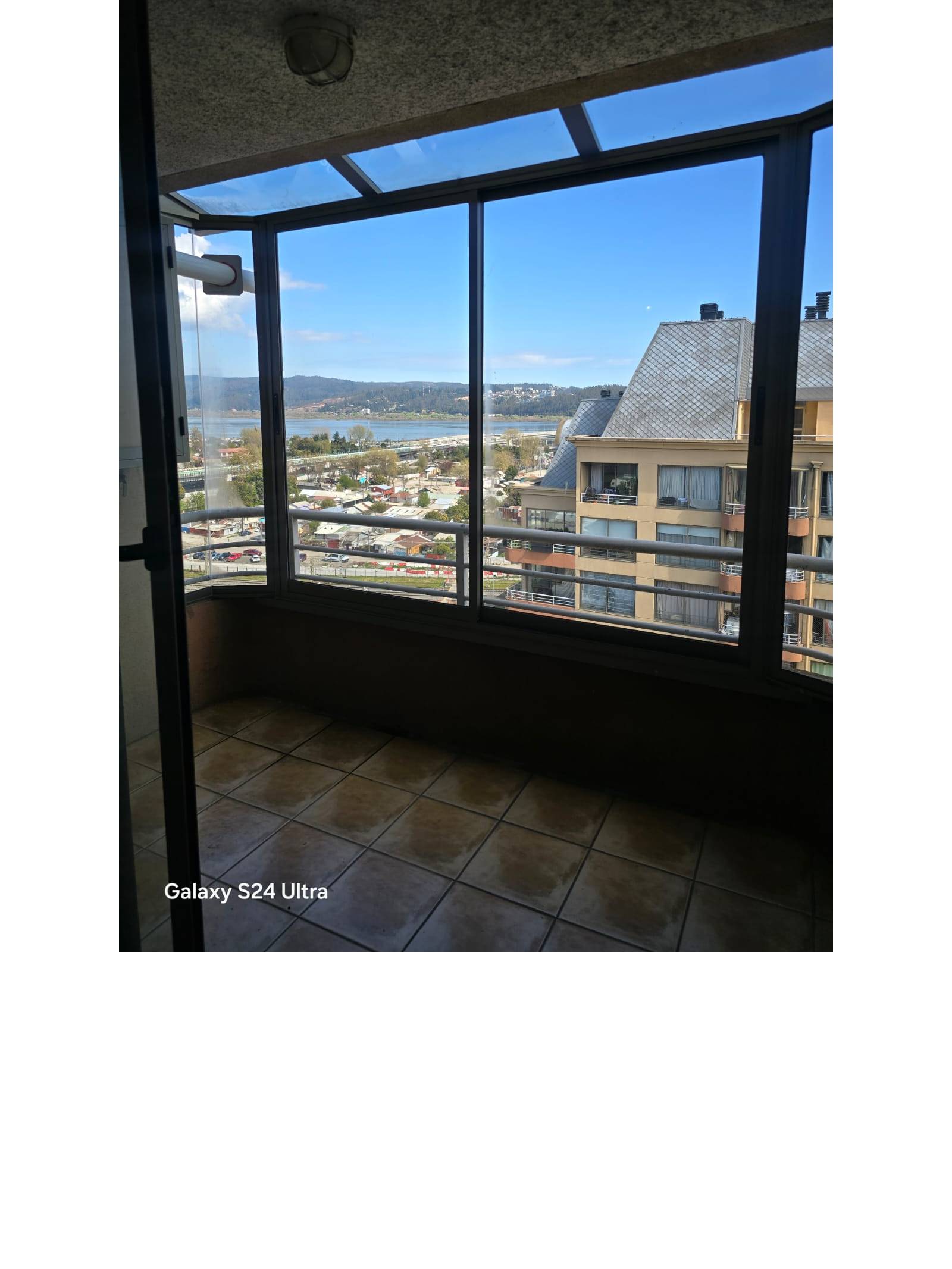 Terraza techada con cerámicos y ventanales panorámicos