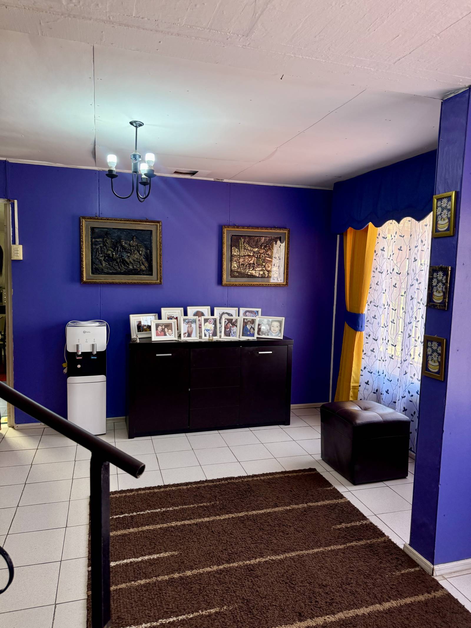 Zona de estar con mueble arrimo y paredes de color morado.