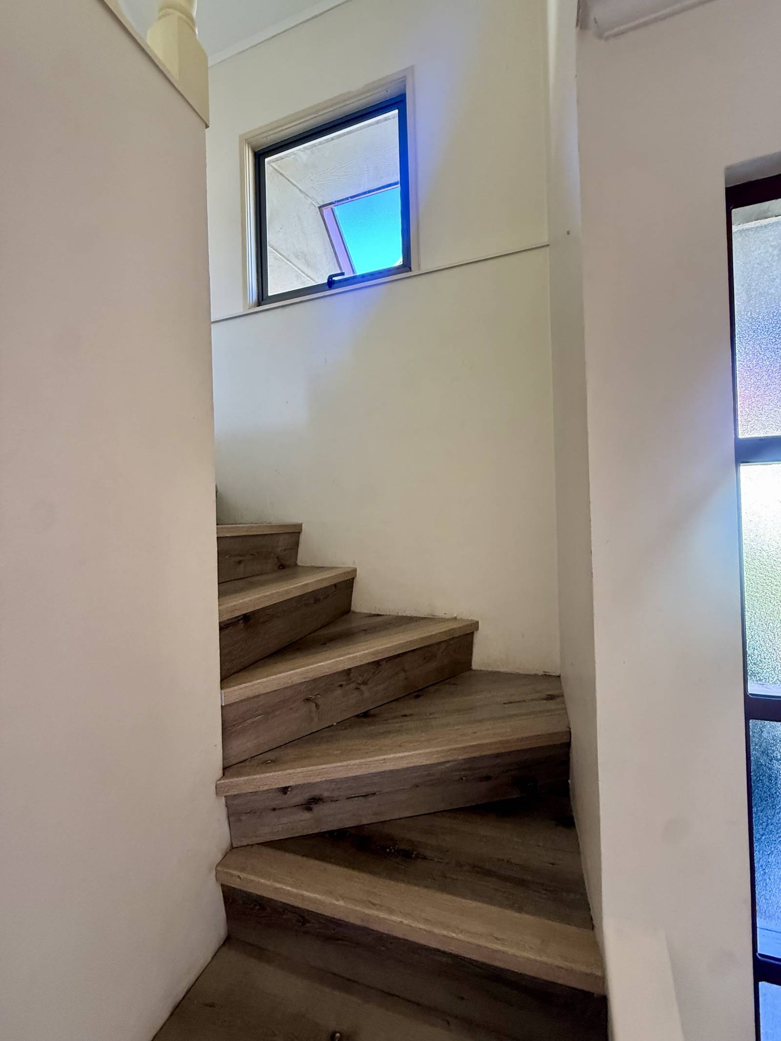 Escalera caracol de madera hacia el segundo piso.