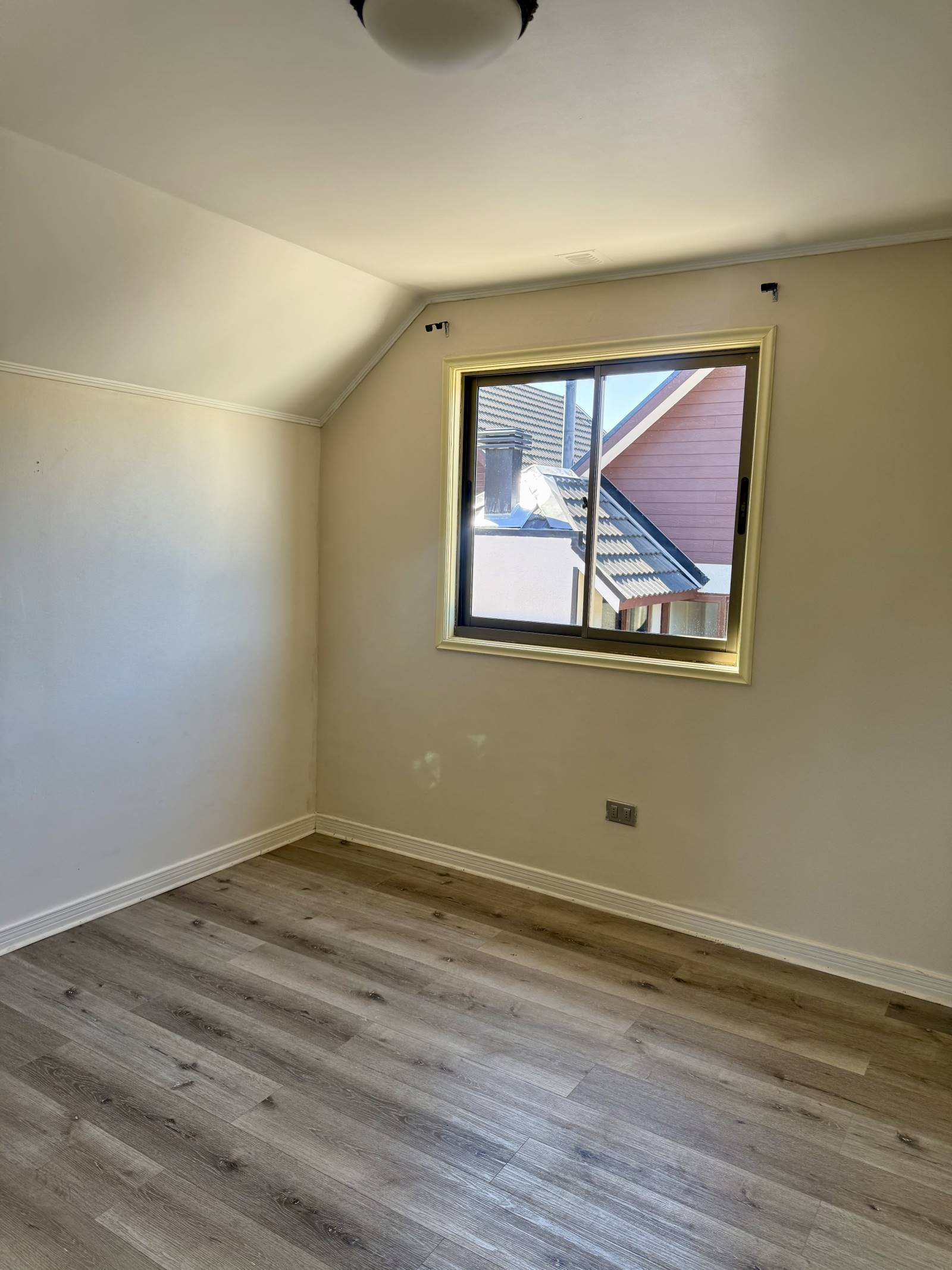 Dormitorio secundario con piso flotante y ventana lateral.