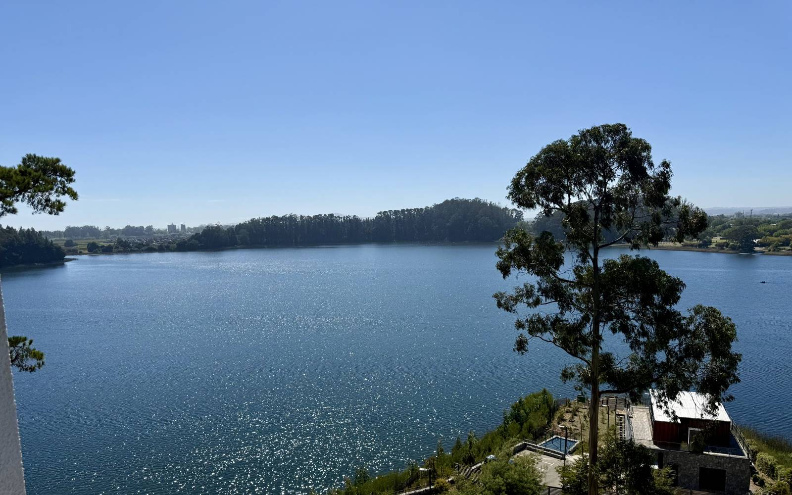 Panorámica despejada hacia la laguna rodeada de cerros y vegetación