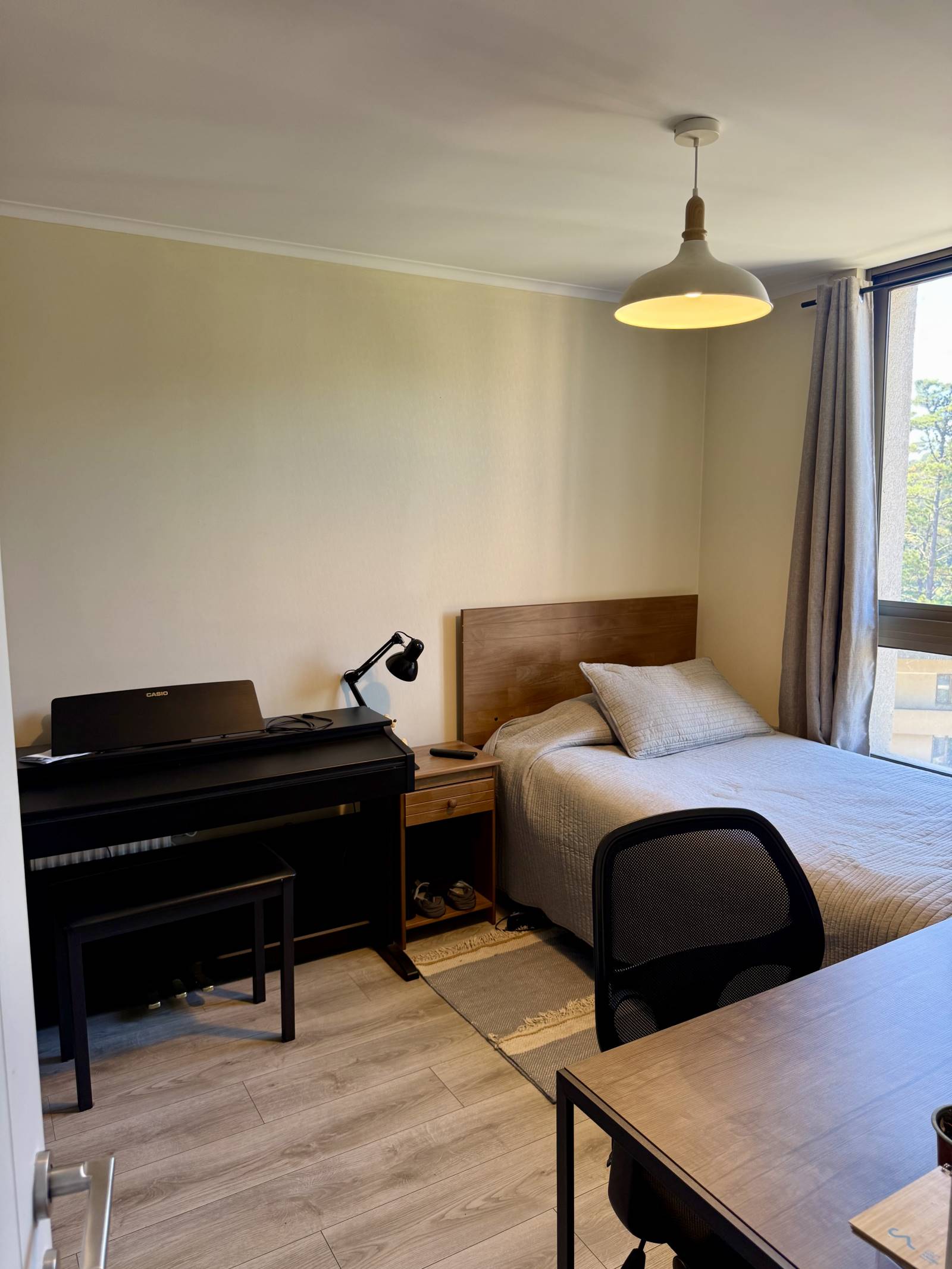 Dormitorio con cama individual, escritorio y teclado musical
